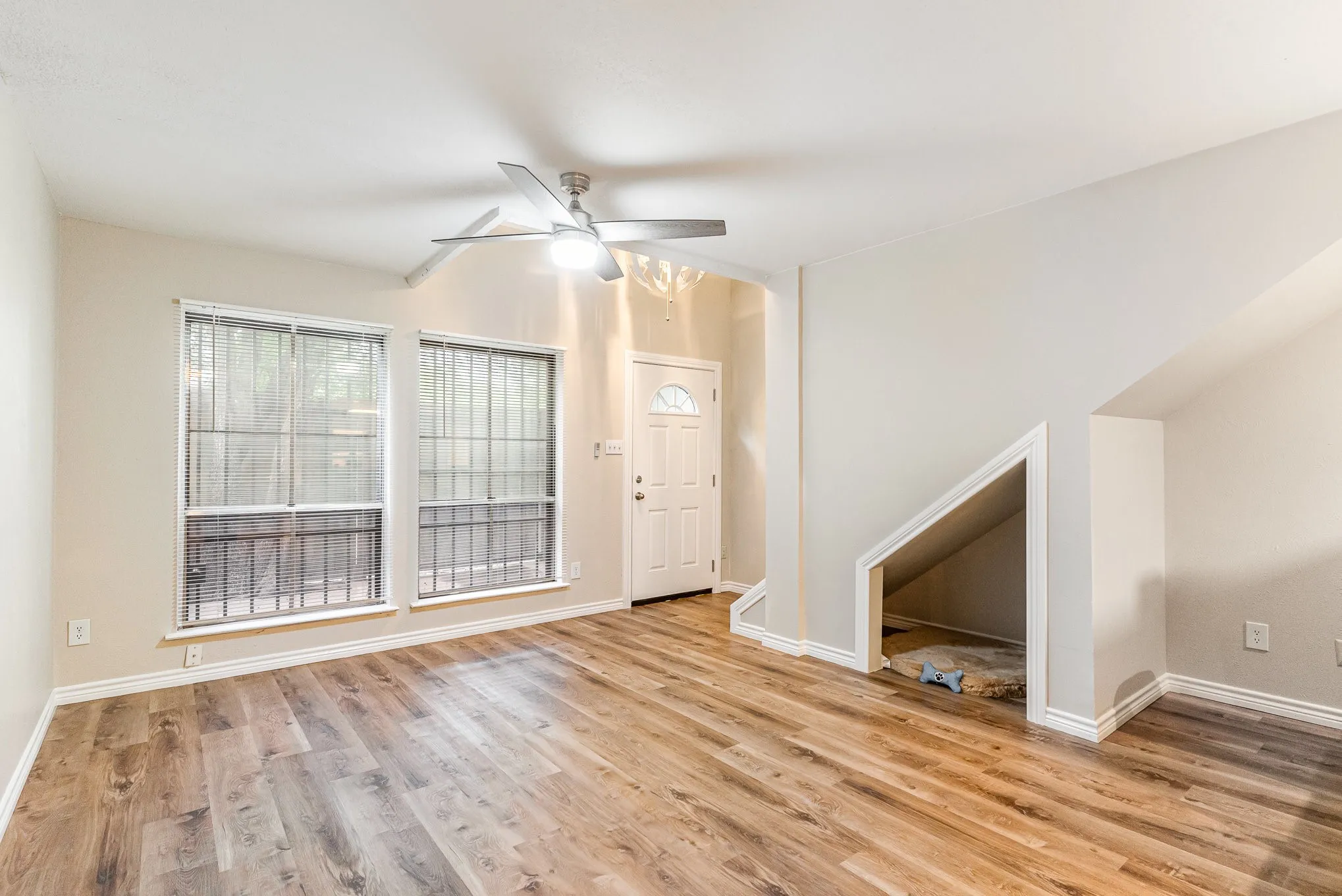 Unfurnished living room with baseboards, a ceiling fan, and wood finished floors