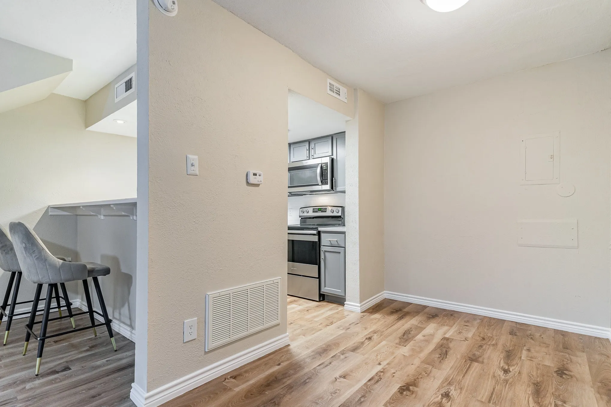 Kitchen with light wood-style floors, visible vents, and stainless steel appliances