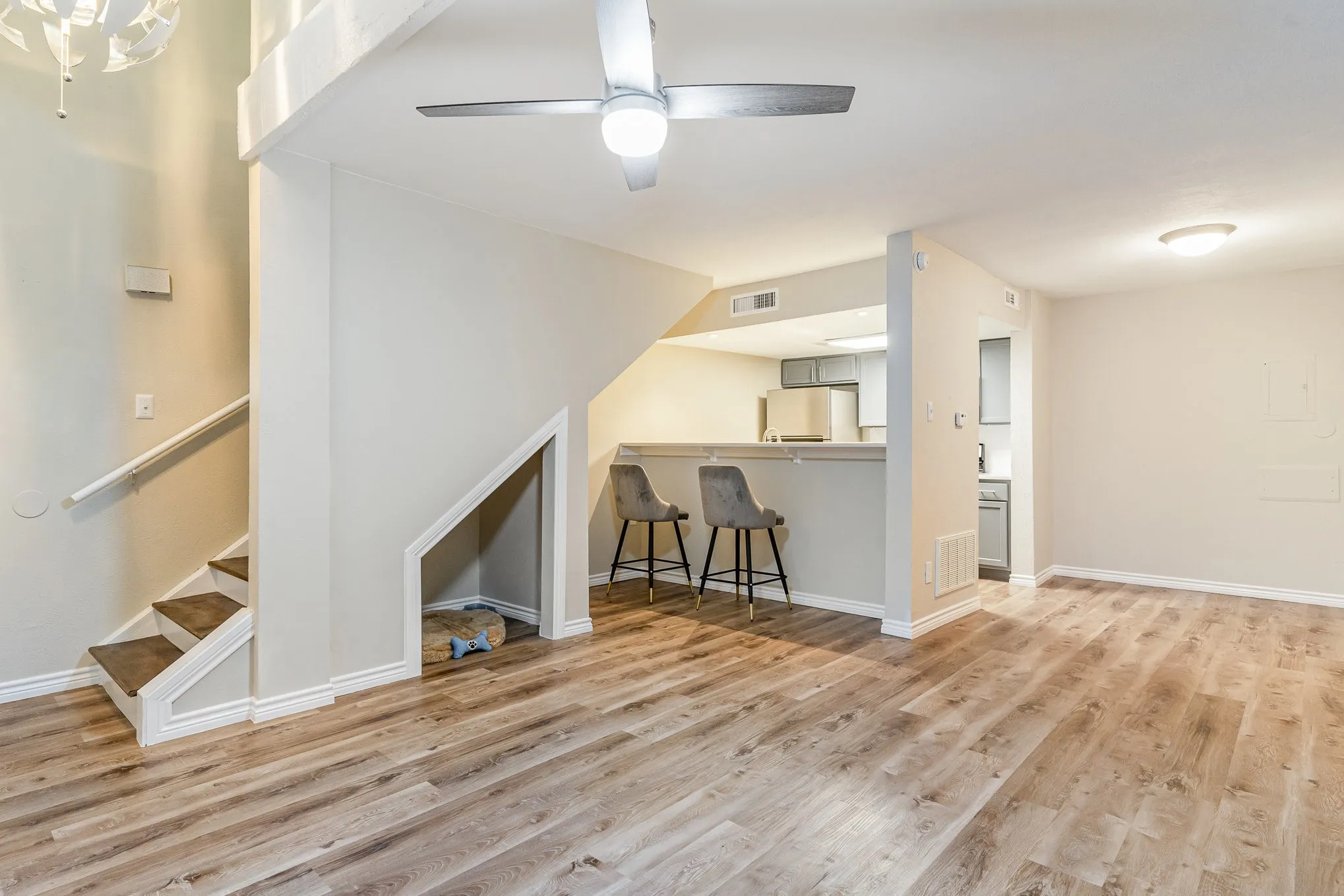 Additional living space with stairs, wood finished floors, ceiling fan, baseboards, and visible vents