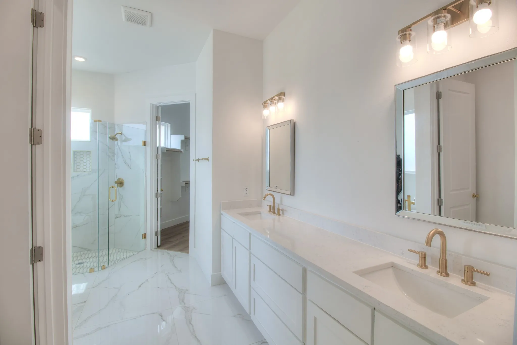 Primary Bathroom bright, contemporary, spa like aesthetic, with double vanity and high end finishes.