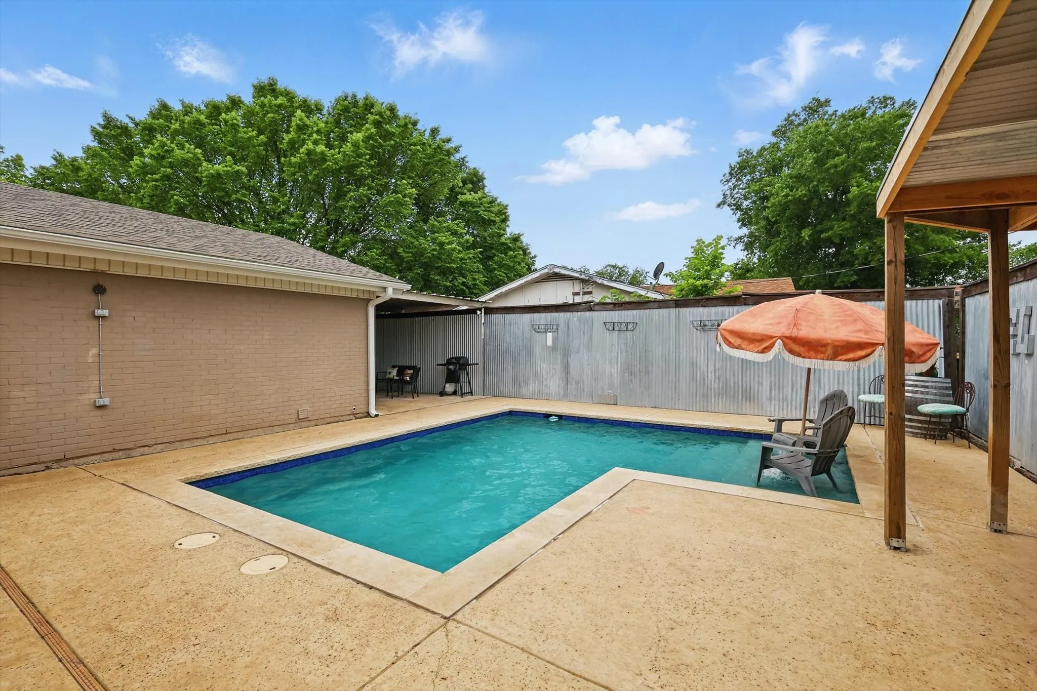 View of swimming pool with a patio and a fenced backyard