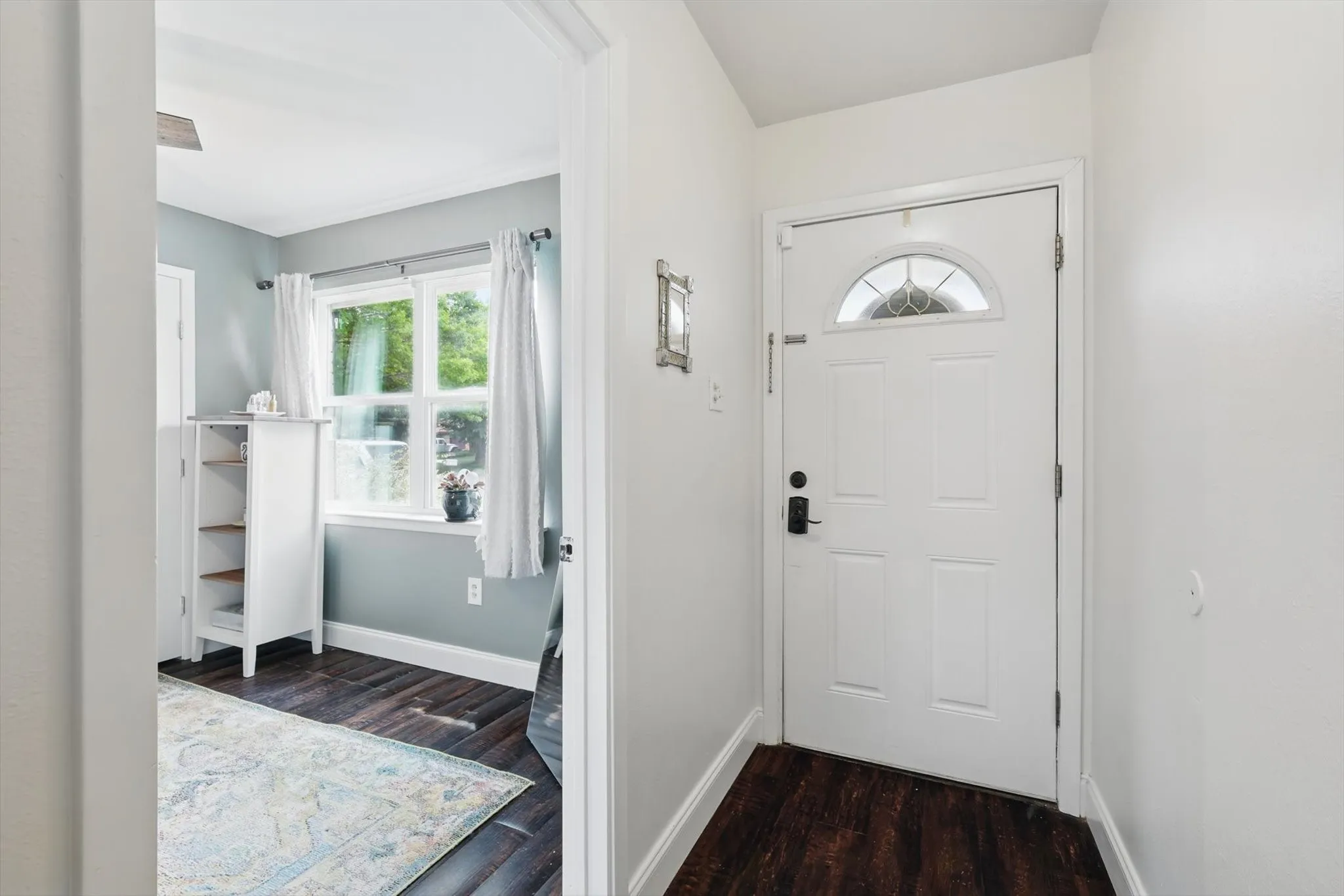 Entrance foyer featuring dark wood-style flooring and baseboards