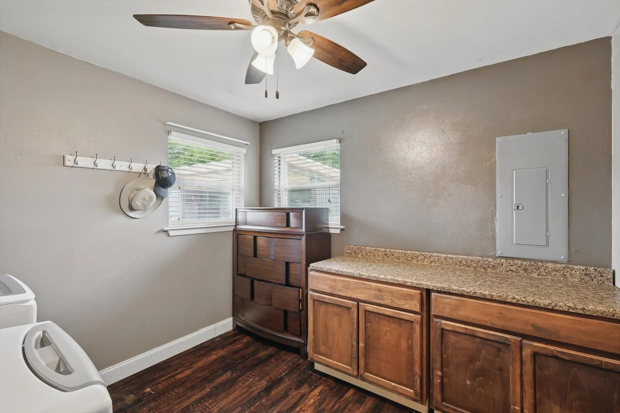 Bathroom with baseboards, ceiling fan, wood finished floors, and electric panel