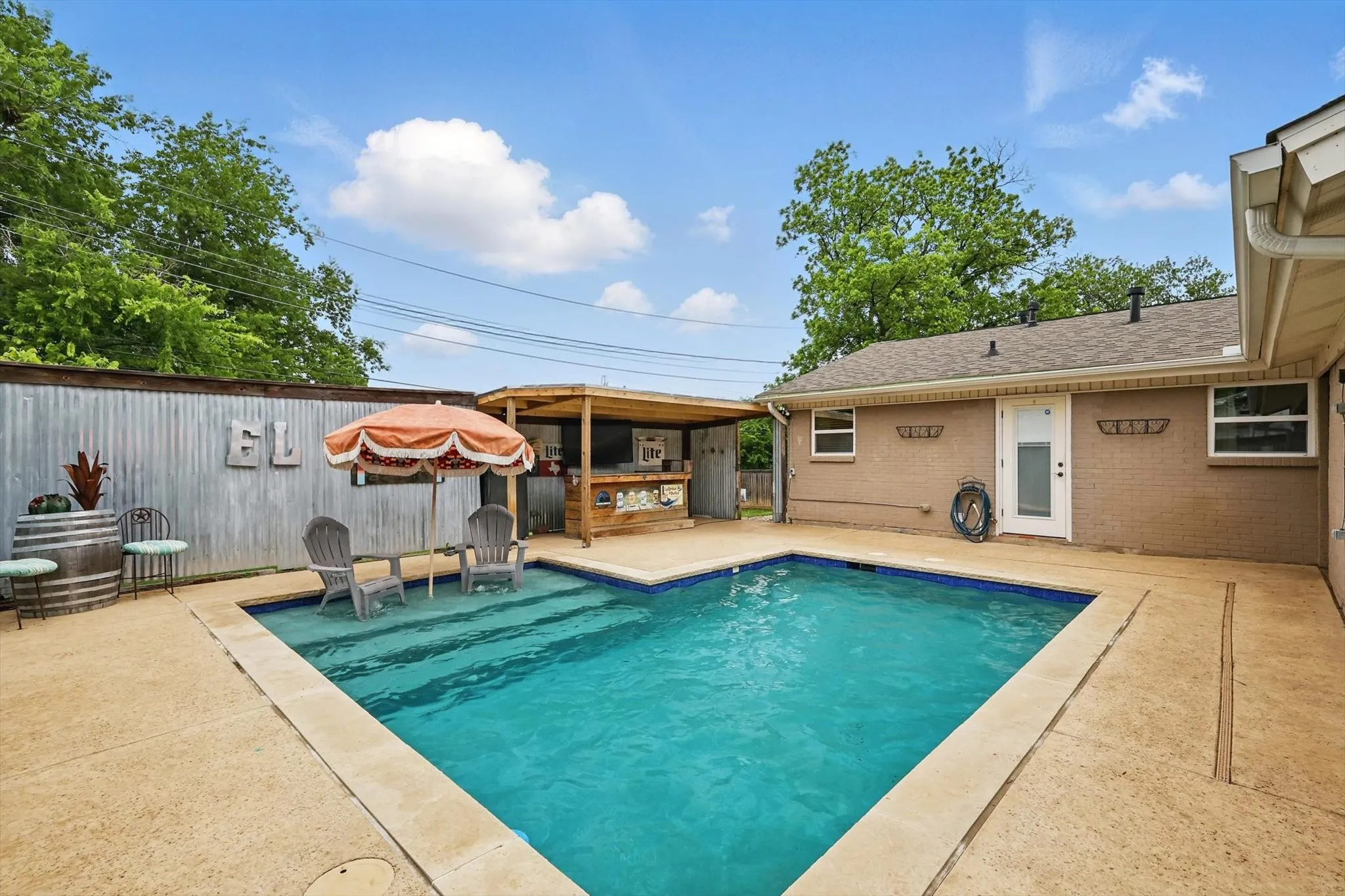 View of swimming pool featuring fence, a fenced in pool, outdoor dry bar, and a patio area