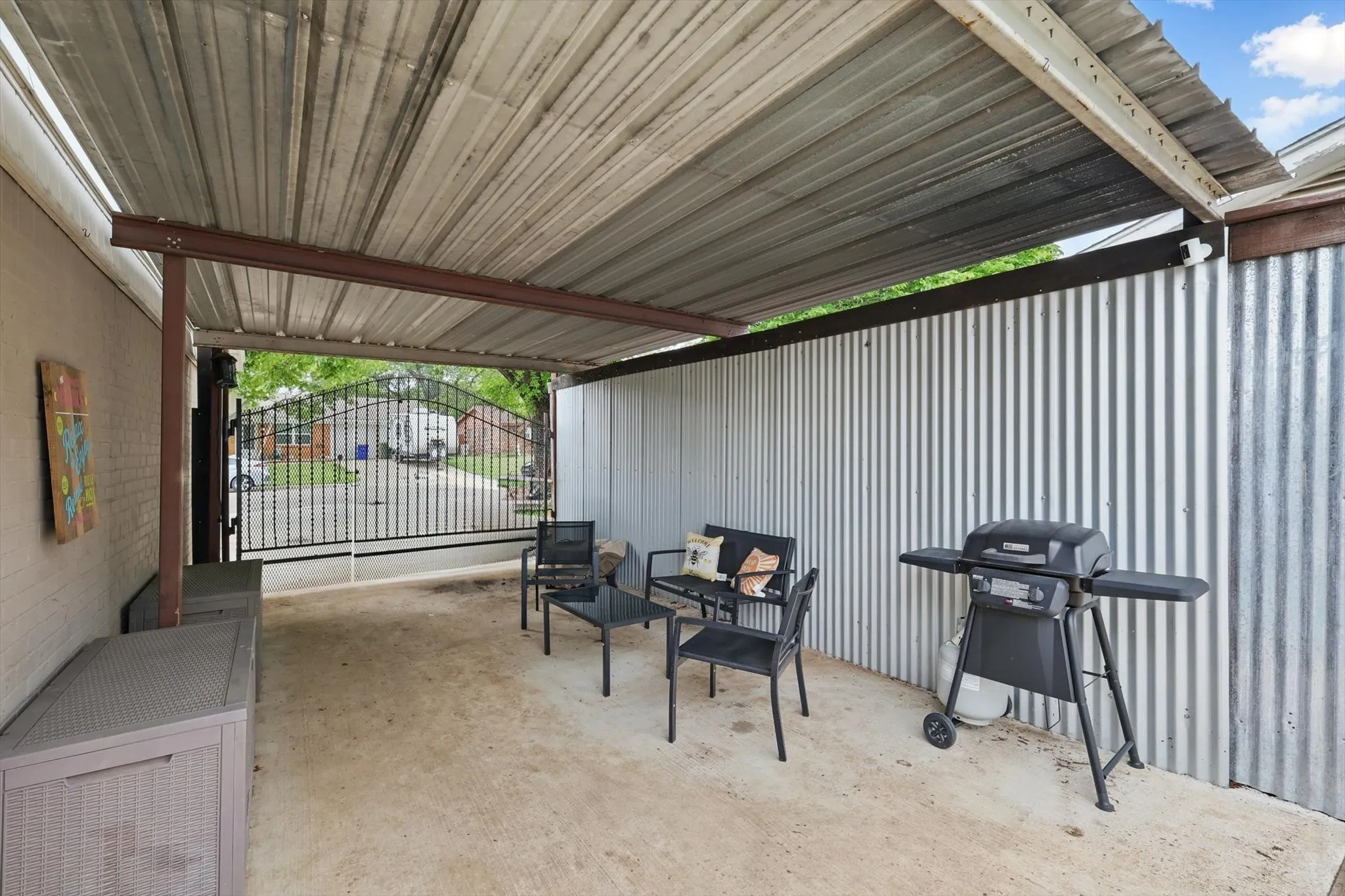 View of patio with a gate and area for grilling