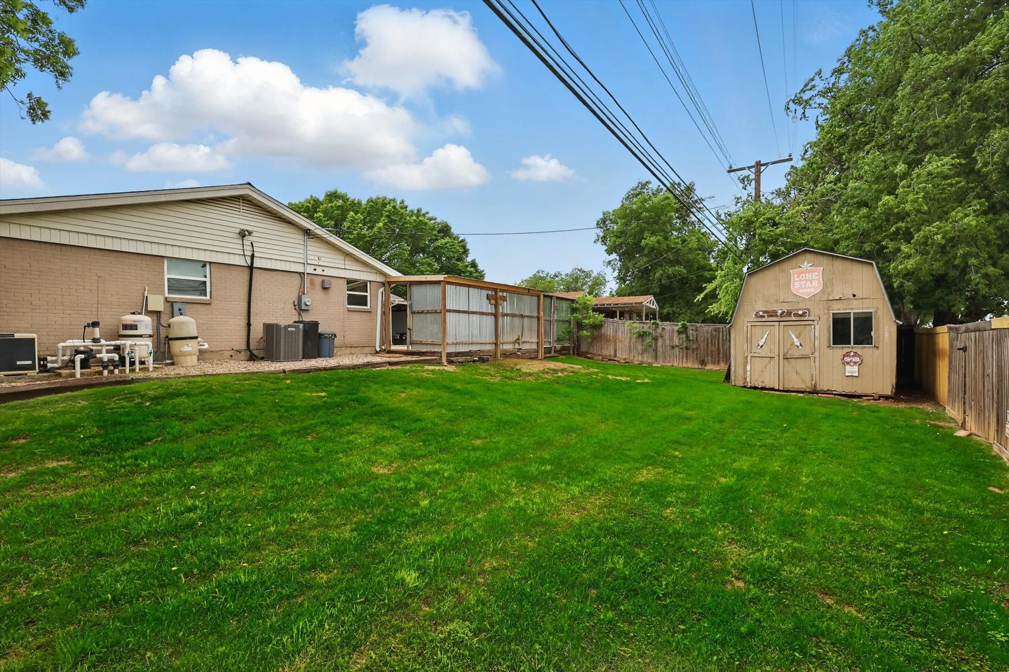 View of yard featuring a fenced backyard, an outdoor structure, cooling unit, and a shed