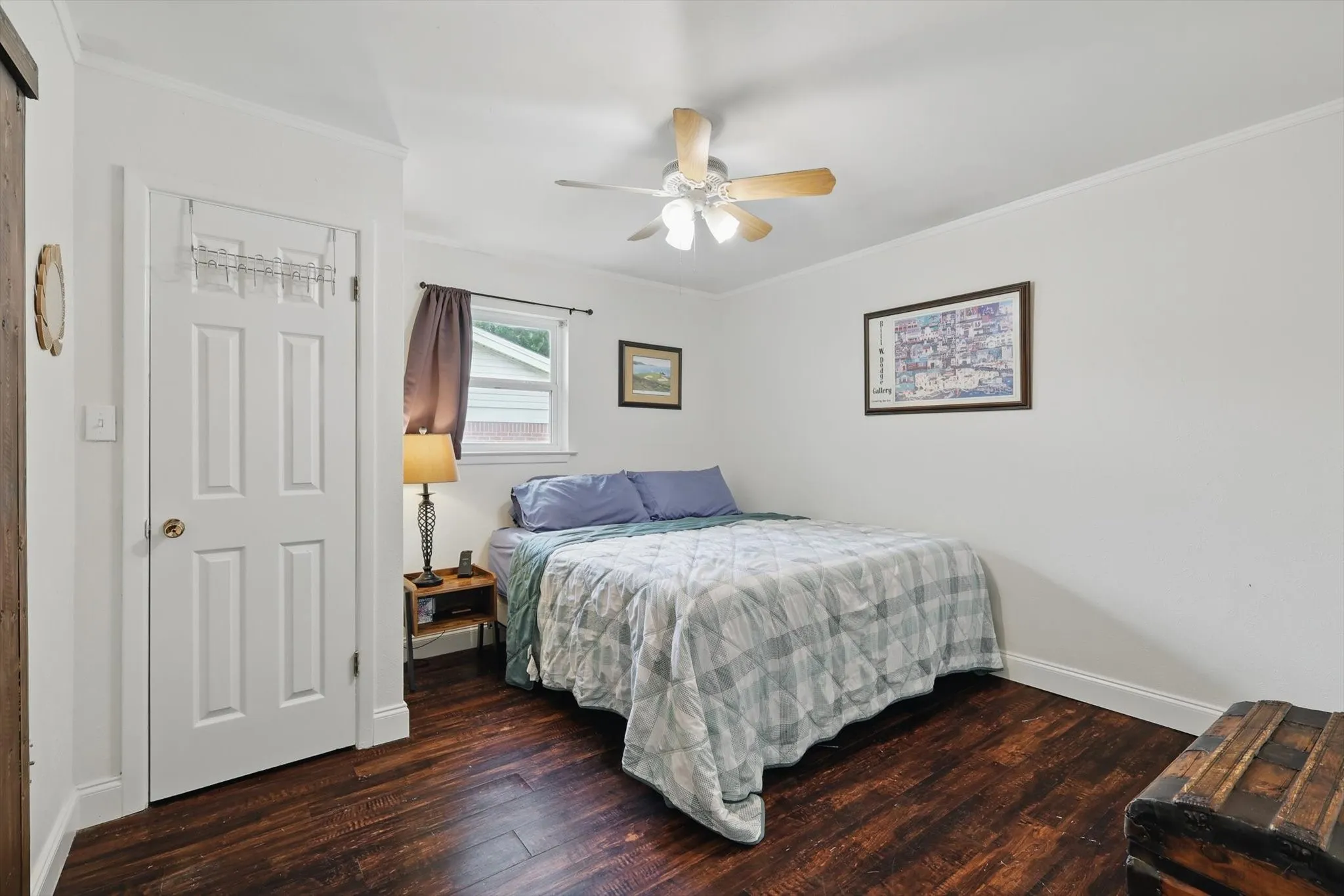 Bedroom featuring crown molding, baseboards, and wood finished floors