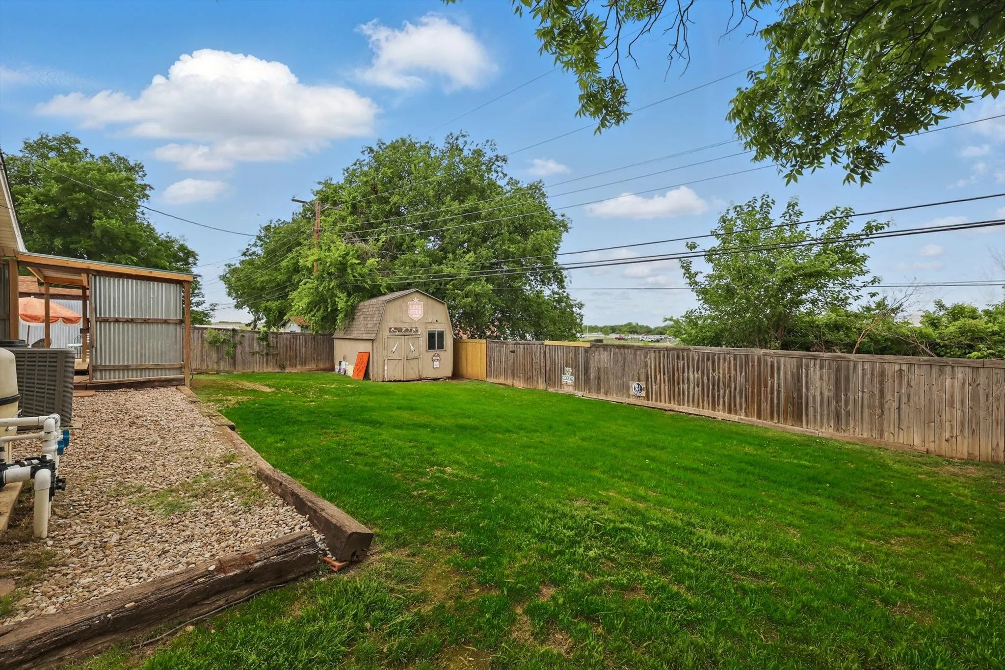 View of yard featuring a fenced backyard, an outdoor structure, and a shed