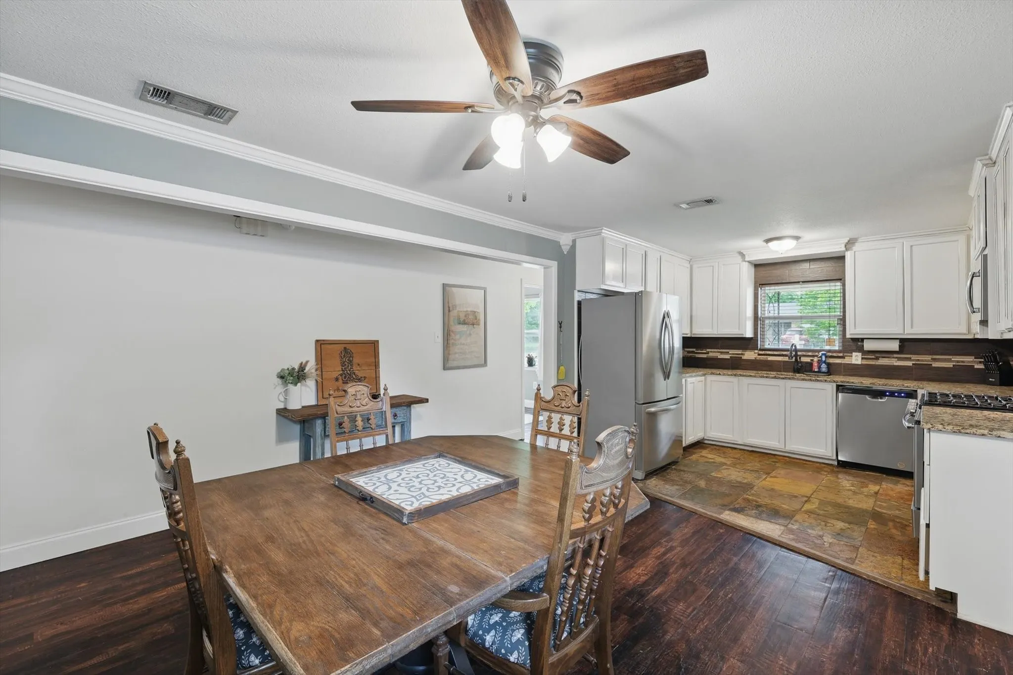 Dining space with visible vents, a ceiling fan, baseboards, and ornamental molding