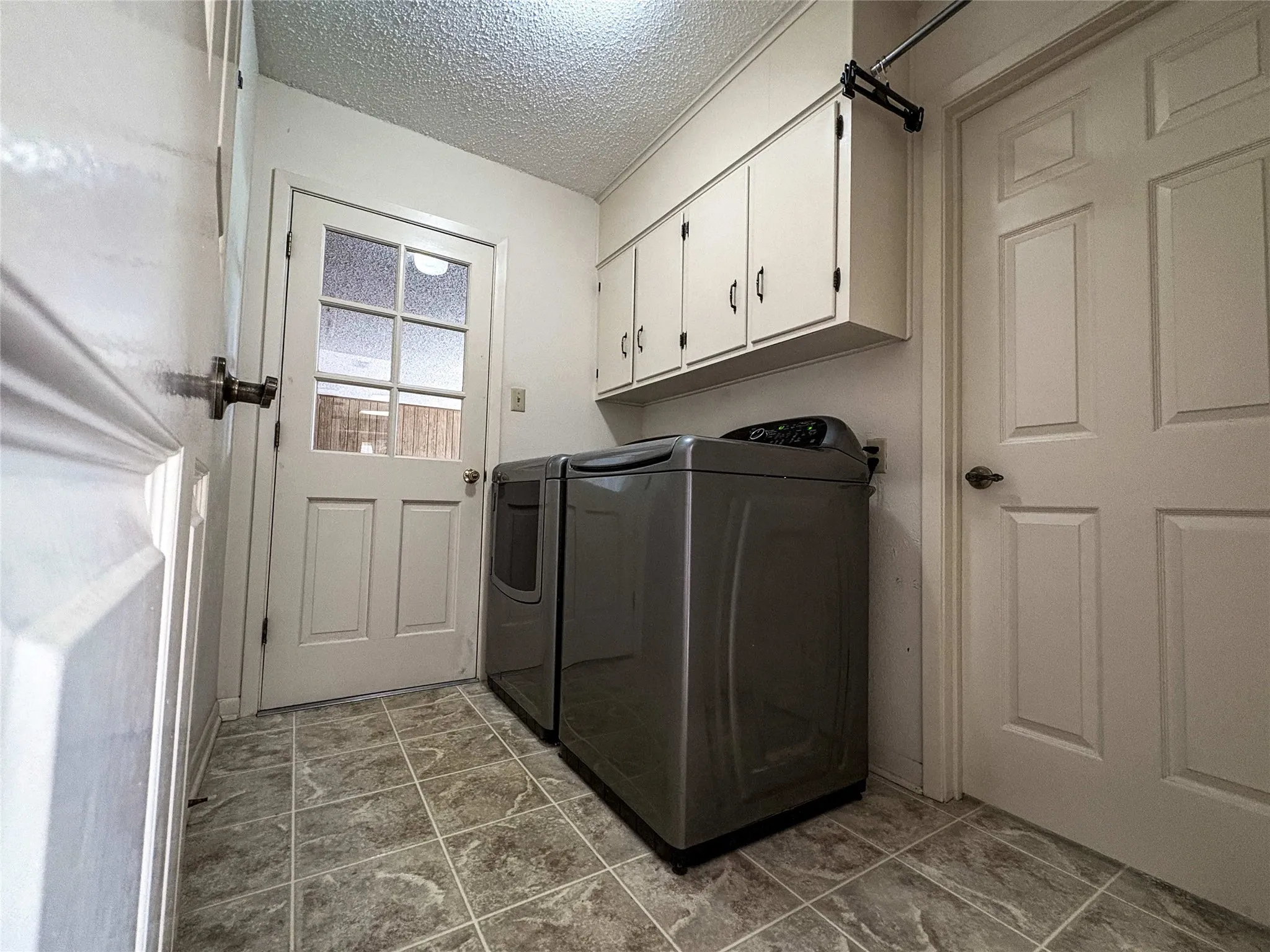 LAUNDRY ROOM OFF GARAGE WITH BUILT IN CABINETS AND HALF BATH
