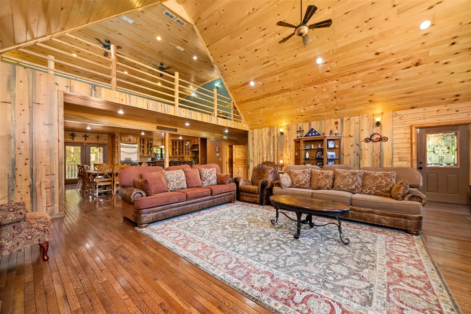 Living room featuring wood ceiling, wooden walls, hardwood / wood-style floors, and ceiling fan
