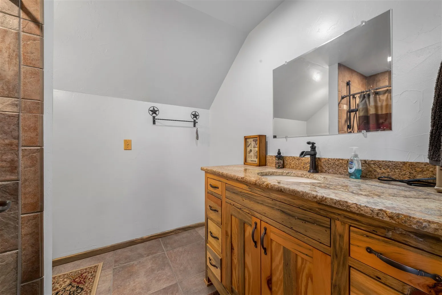 Bathroom featuring baseboards, vaulted ceiling, vanity, and a shower with shower curtain