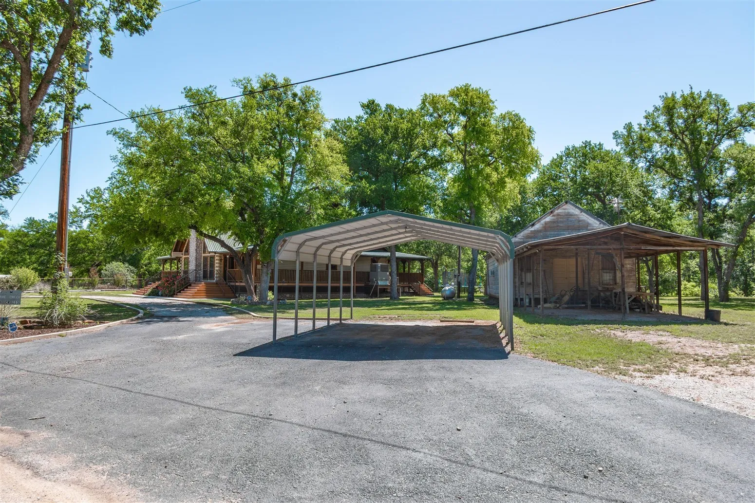 View of parking / parking lot featuring driveway, a carport, and playground community