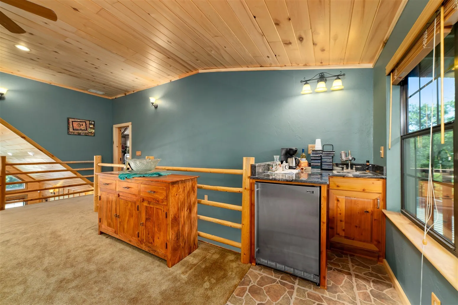 Bar with lofted ceiling, a ceiling fan, stainless steel refrigerator, a sink, and wood ceiling