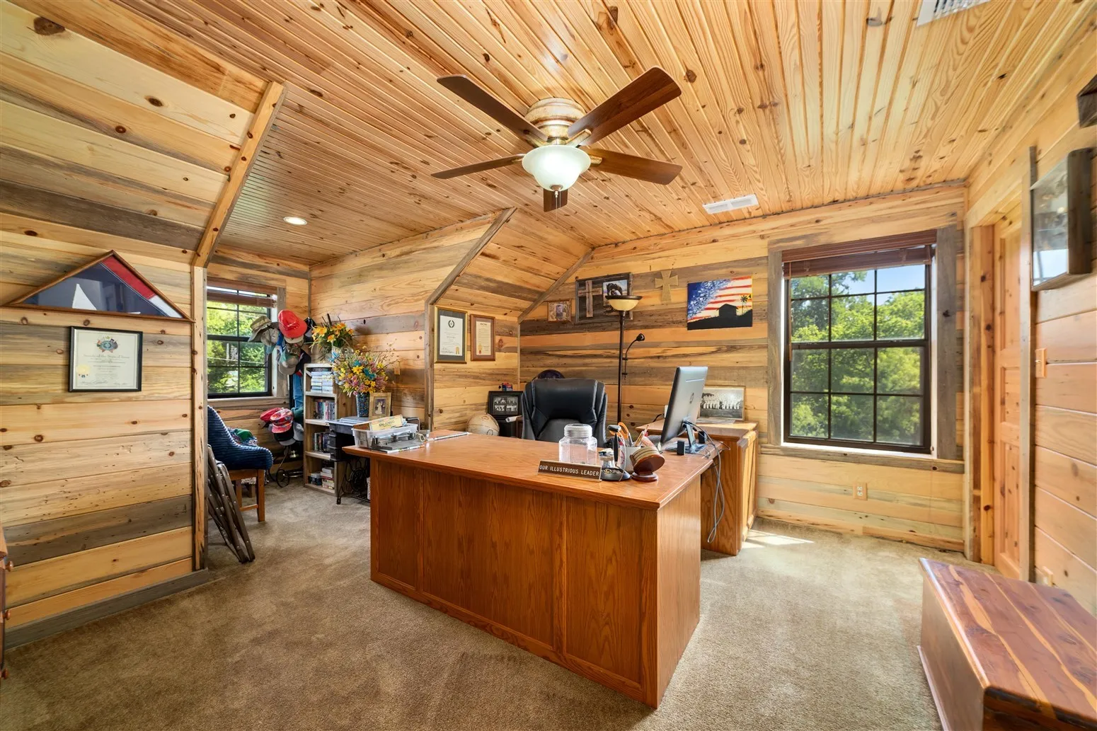 Office area with wood ceiling, carpet flooring, wooden walls, and plenty of natural light