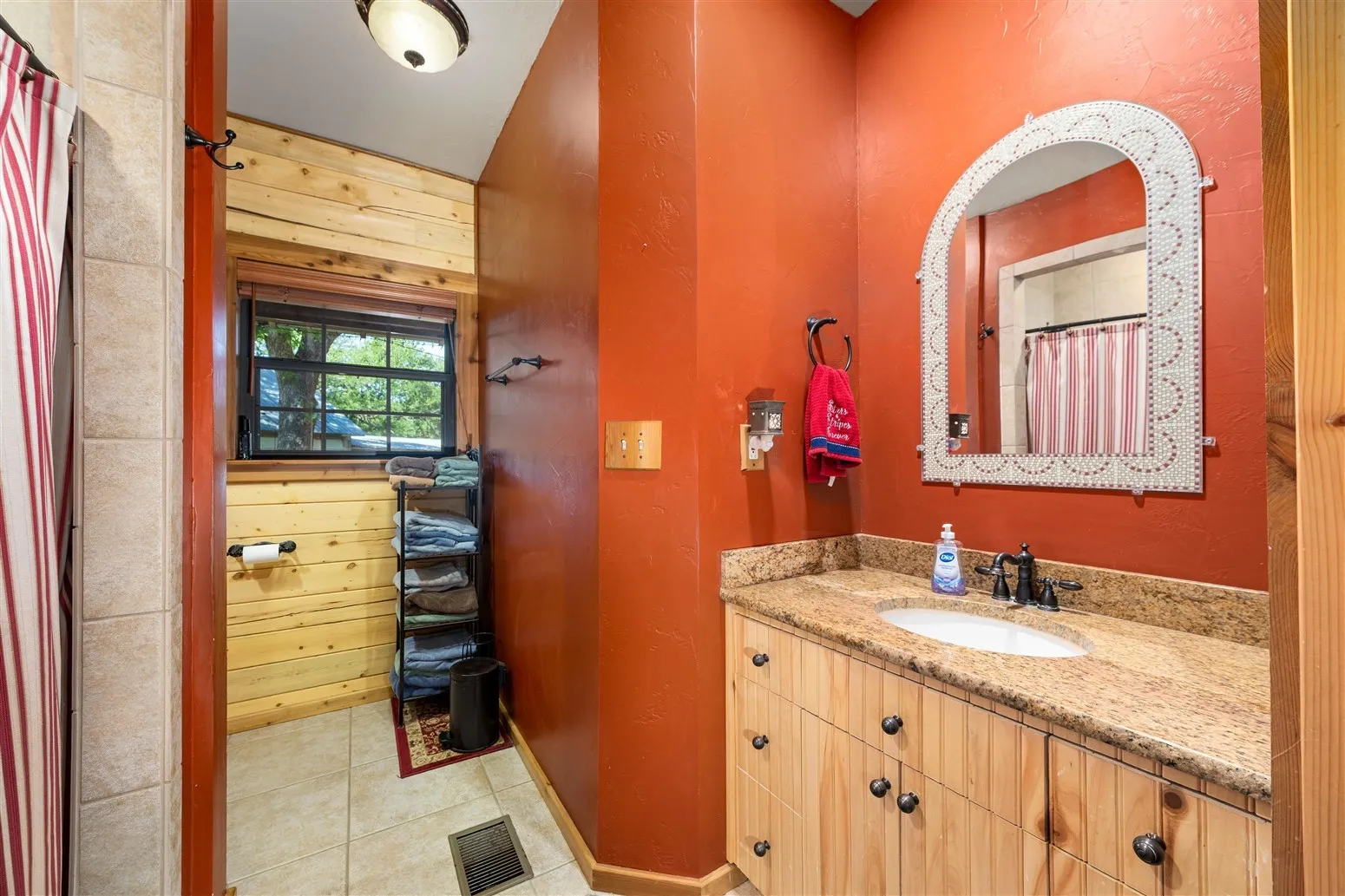 Bathroom with curtained shower, visible vents, tile patterned flooring, and vanity