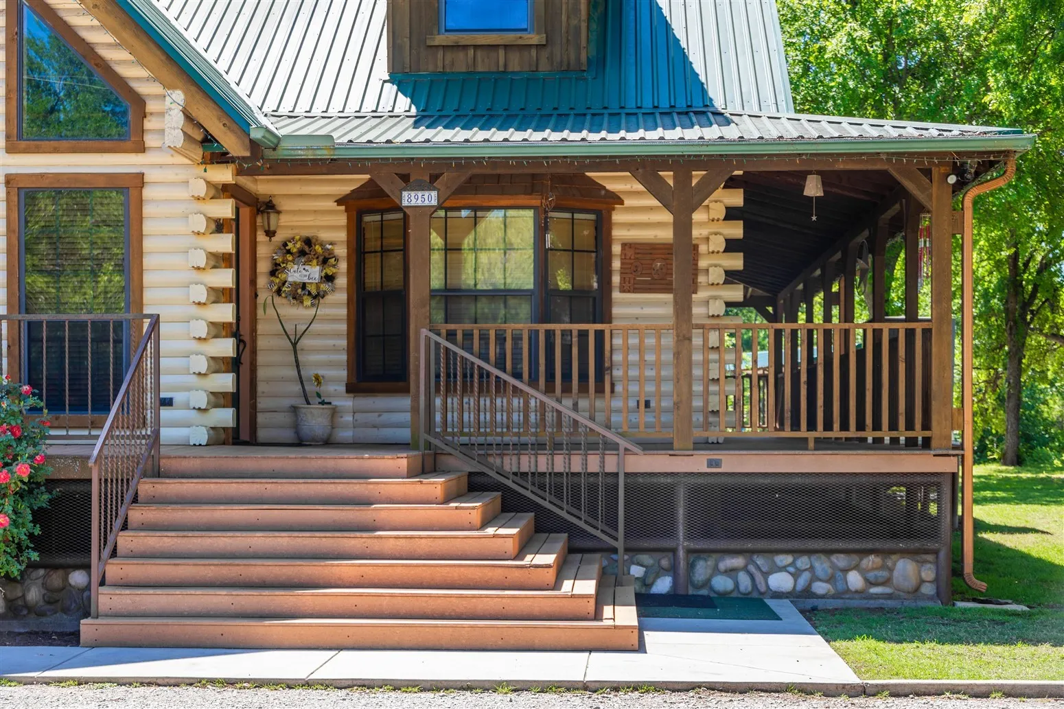View of exterior entry featuring log exterior, a porch, and metal roof