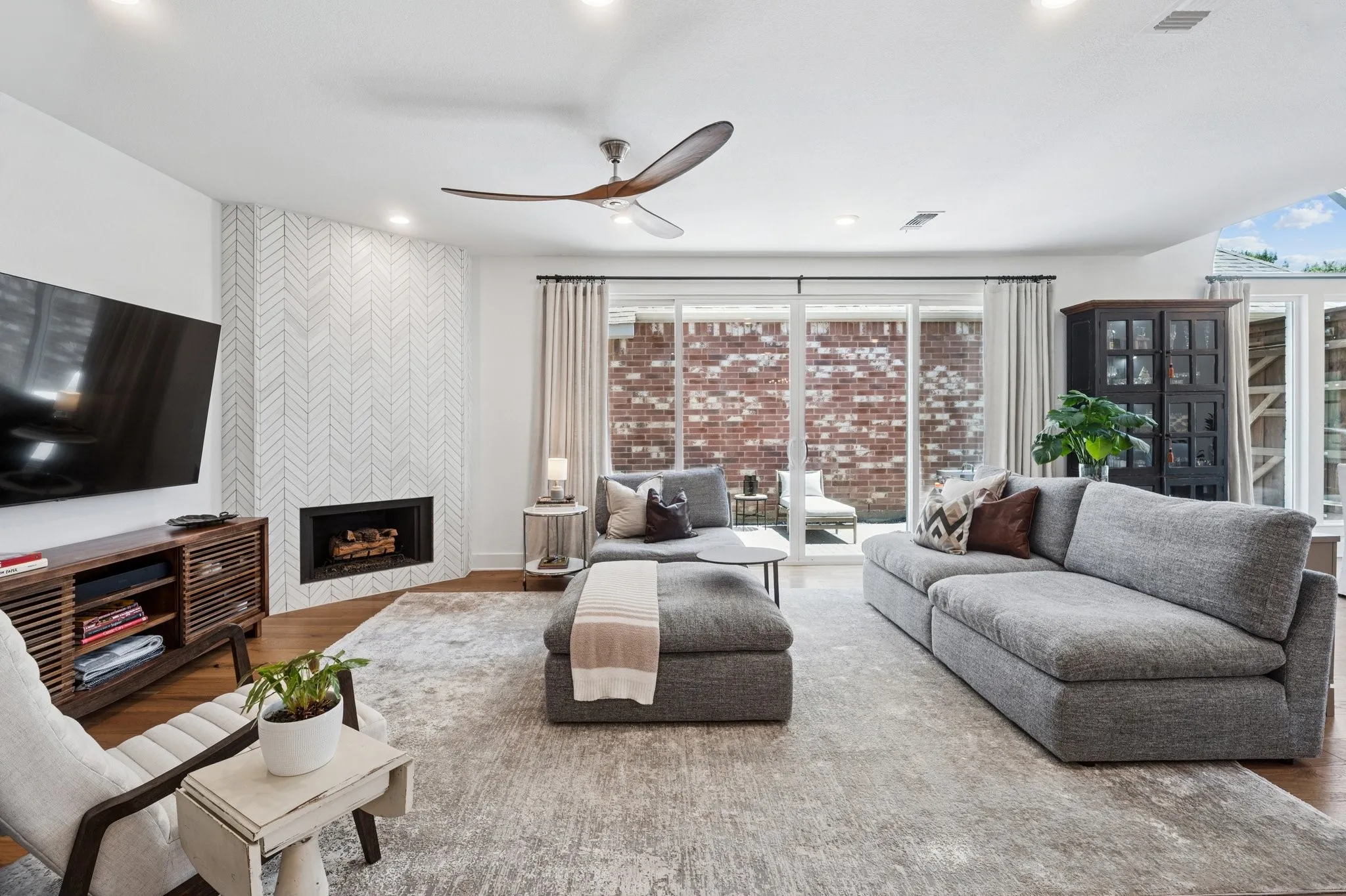 Living room featuring wood finished floors, a fireplace, recessed lighting, and a ceiling fan