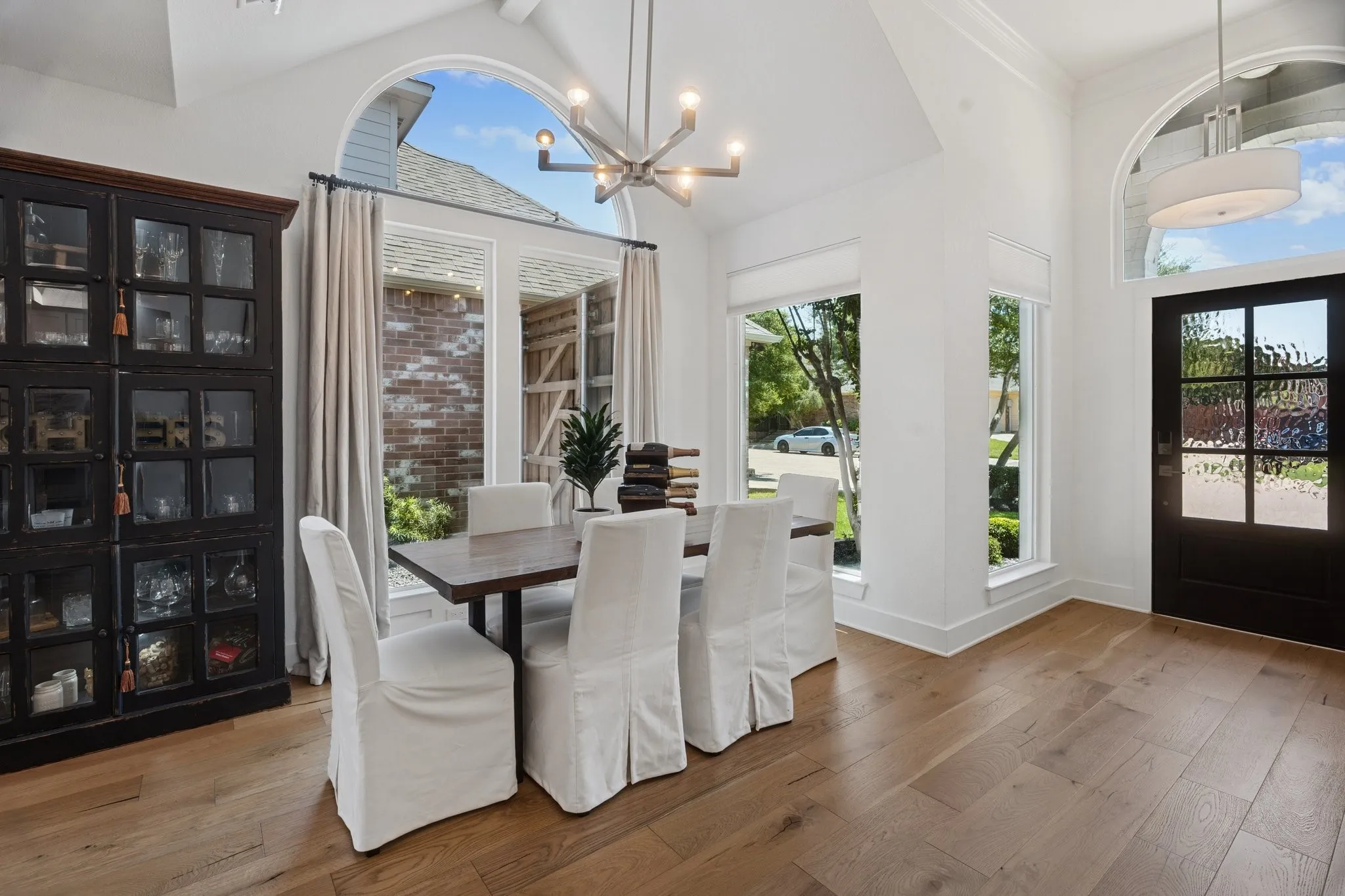 Dining room featuring wood-type flooring, high vaulted ceiling, a chandelier, and beamed ceiling