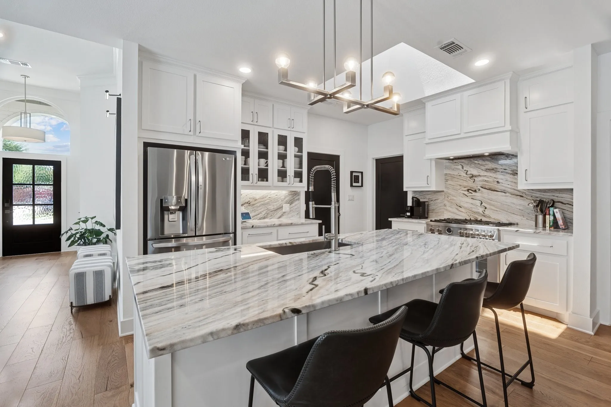 Kitchen featuring stainless steel fridge with ice dispenser, light wood-style flooring, white cabinetry, and recessed lighting