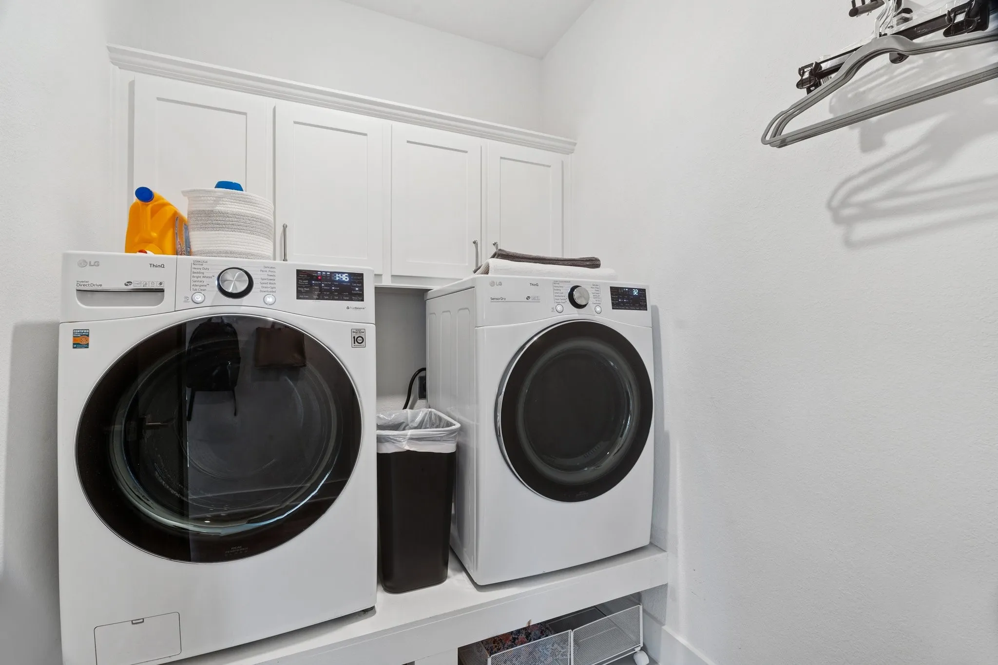 Washroom featuring separate washer and dryer and cabinet space