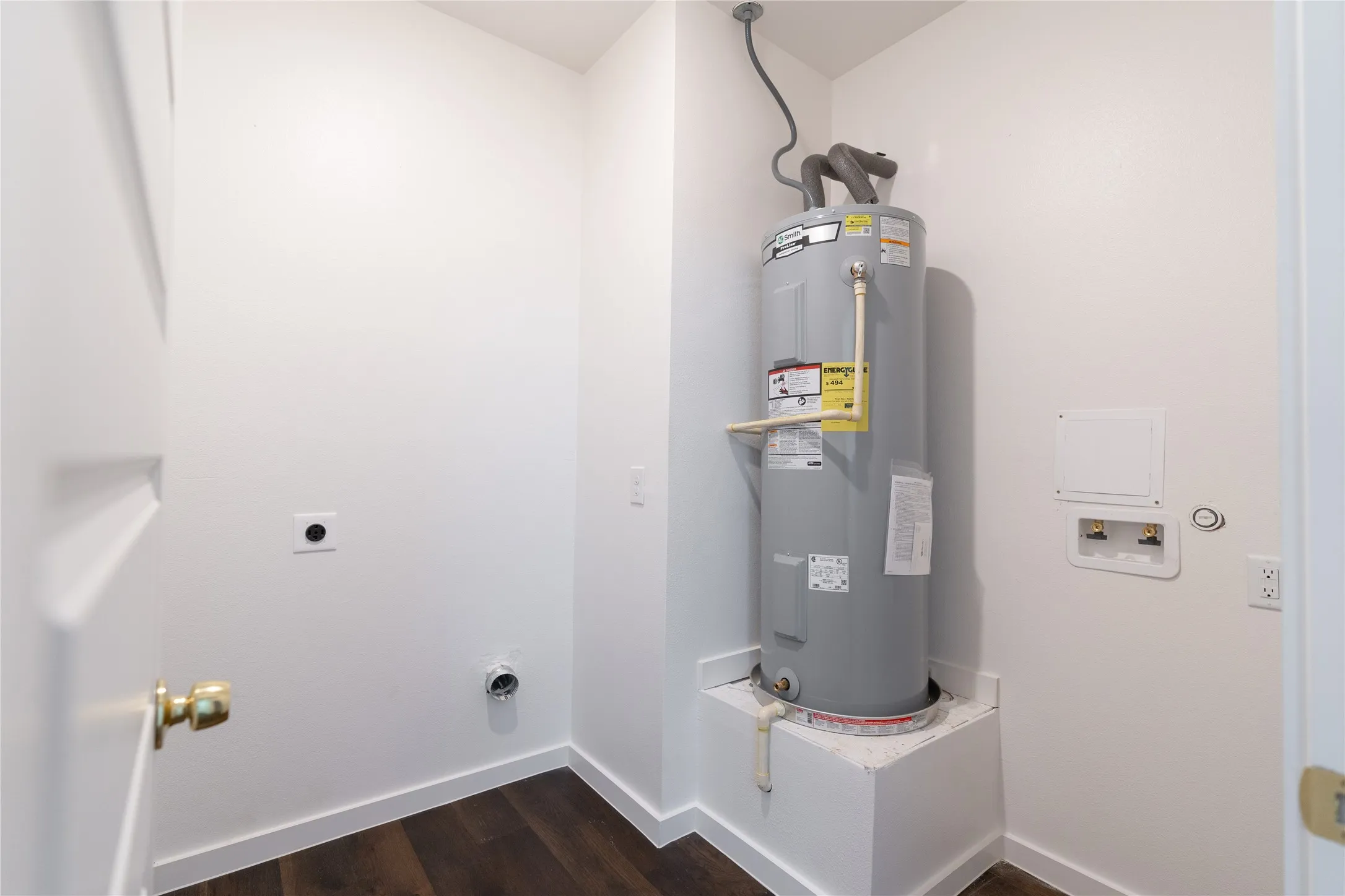 Washroom featuring hookup for an electric dryer, electric water heater, washer hookup, laundry area, and dark wood finished floors