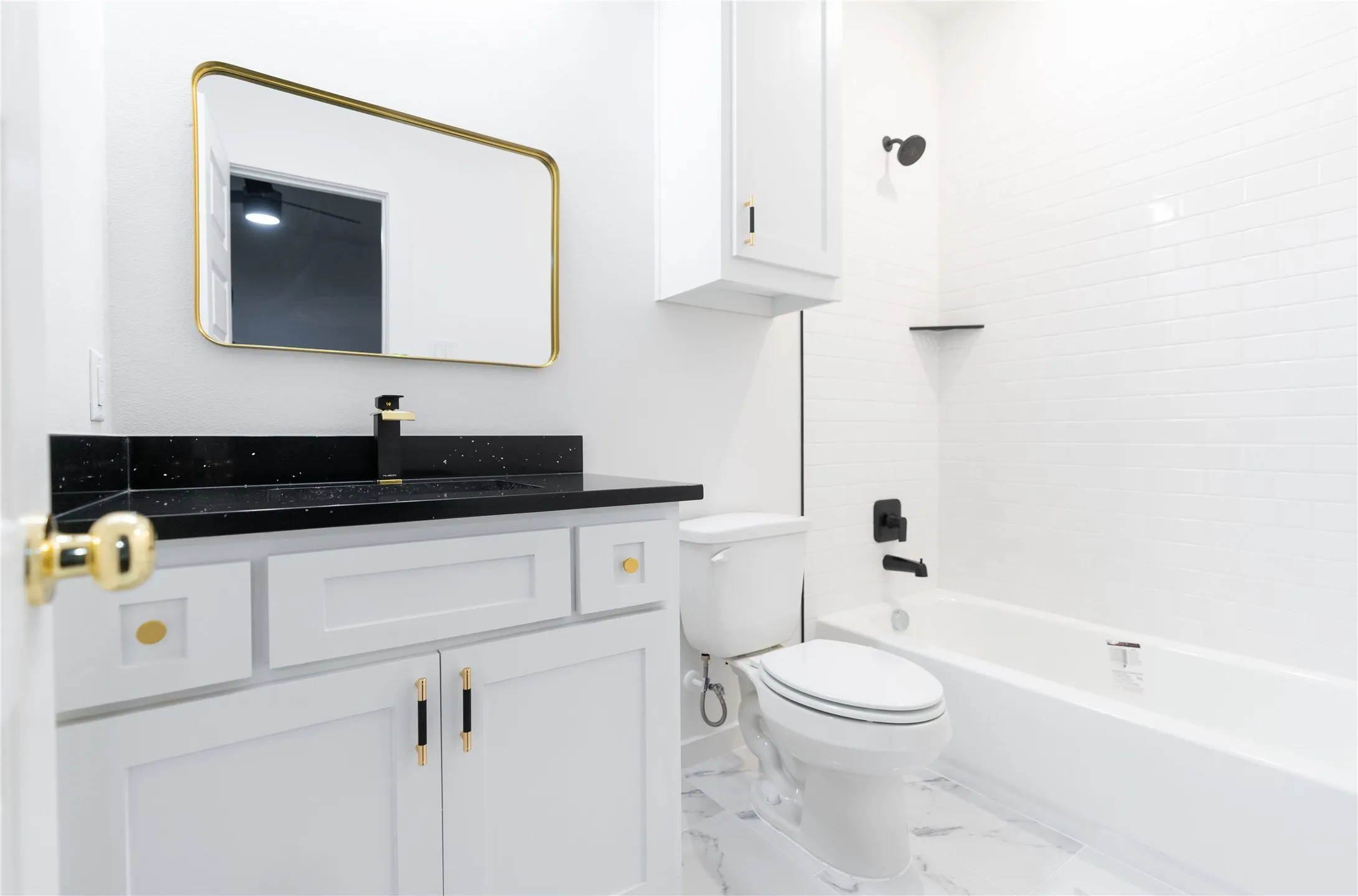Bathroom featuring marble finish floor, toilet, shower / tub combination, vanity, and baseboards