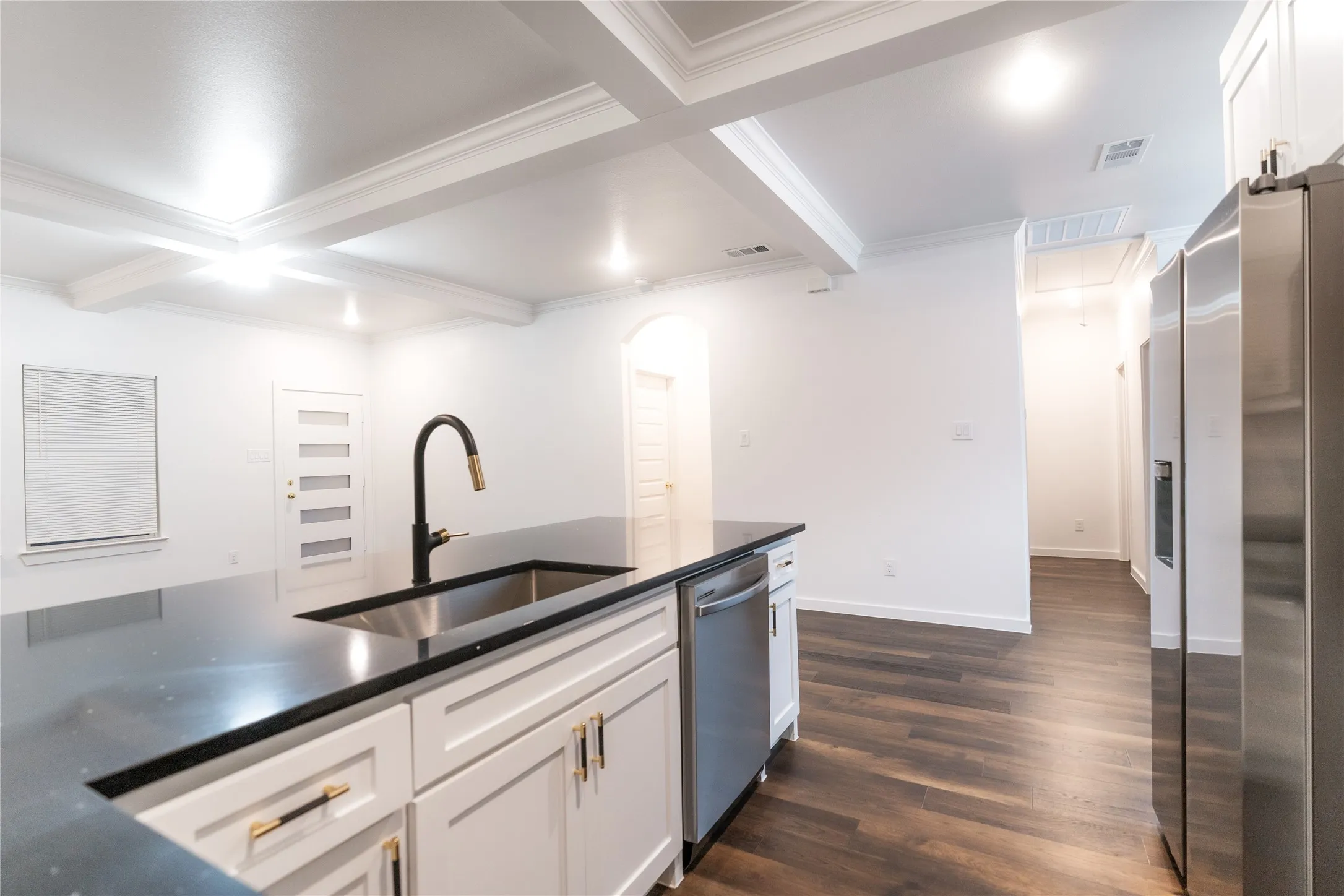 Kitchen featuring visible vents, stainless steel appliances, beamed ceiling, and a sink