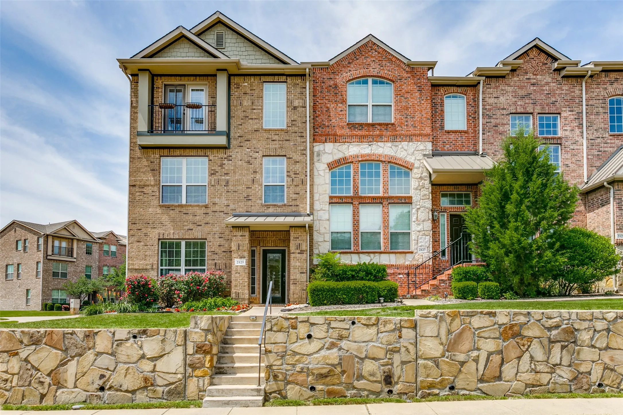 View of property featuring brick siding and a standing seam roof