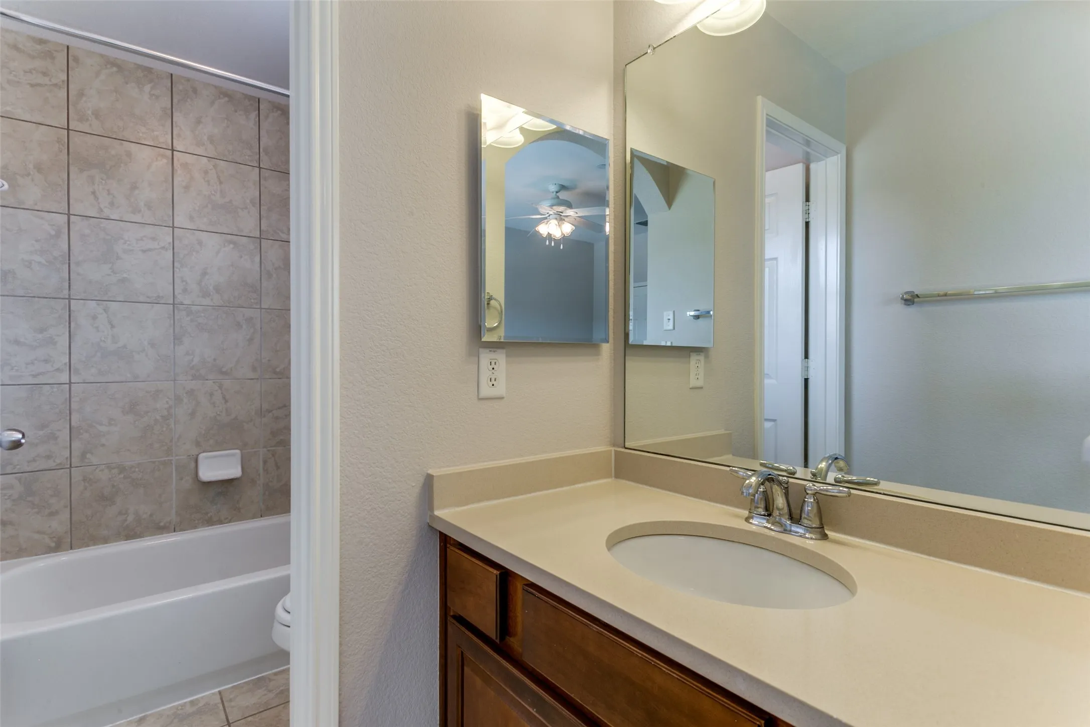 Full bathroom with tile patterned flooring, ceiling fan, toilet, vanity, and tub / shower combination