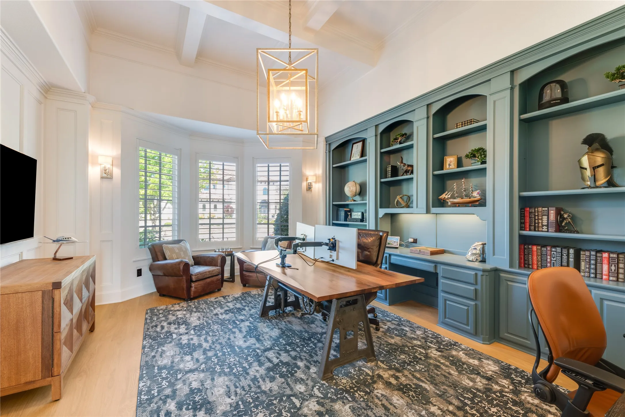 A handsome study that blends cozy comfort with modern charm. In addition to the sleek built-ins, tray ceiling & bay windows, to the left is a discreet secret panel that leads to a tornado-safe room.