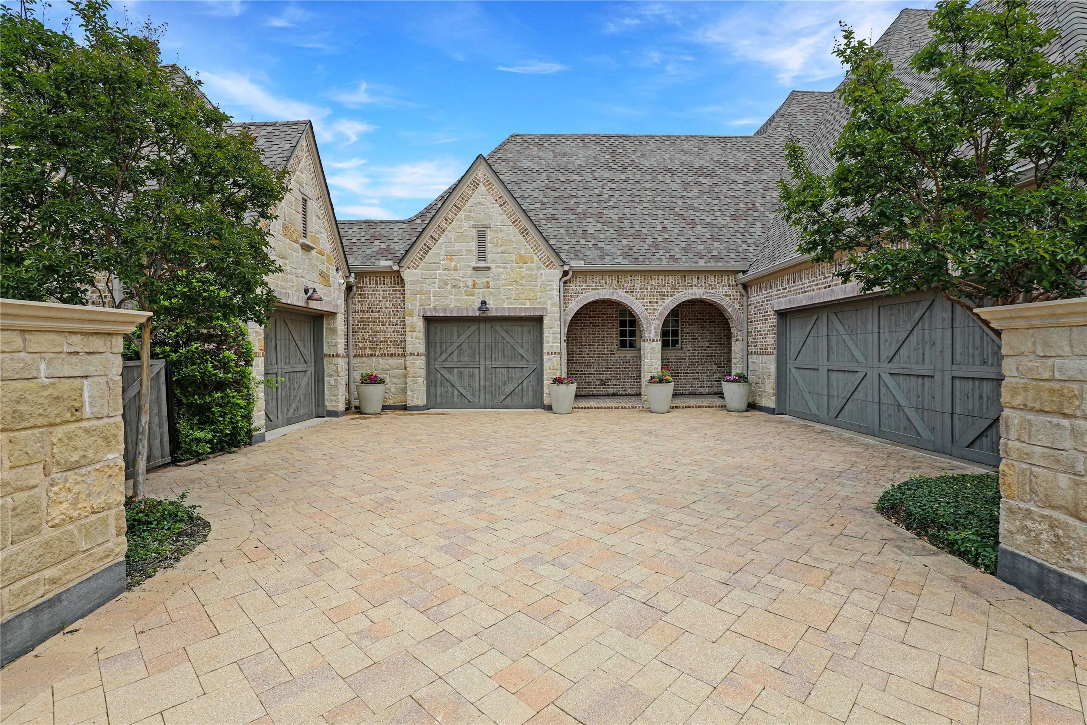 Oversized, split 4-car garage with epoxy floors, hanging storage racks, a workbench & built-in cabinets for storage galore. Tesla wall charger too.
