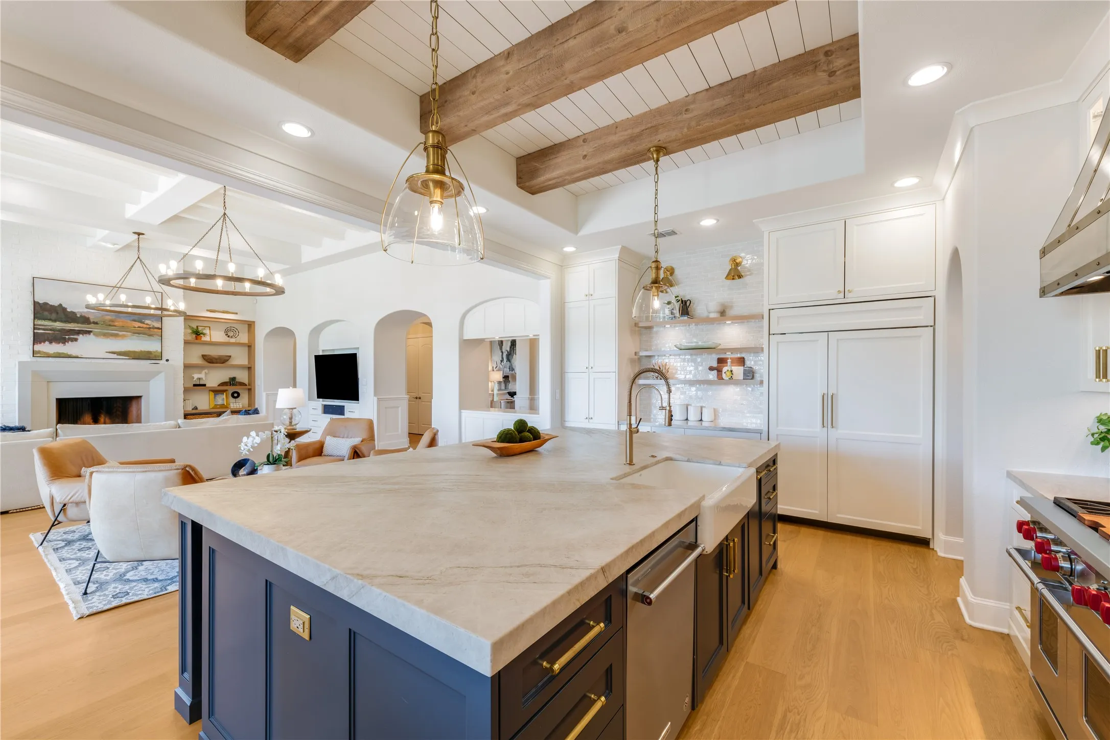 Love the beamed ceiling that compliments the European White Oak floors. One of two refrigerator/freezers, see the 48" Sub-Zero blending with the custom cabinetry. Gold hardware on the cabinet doors.