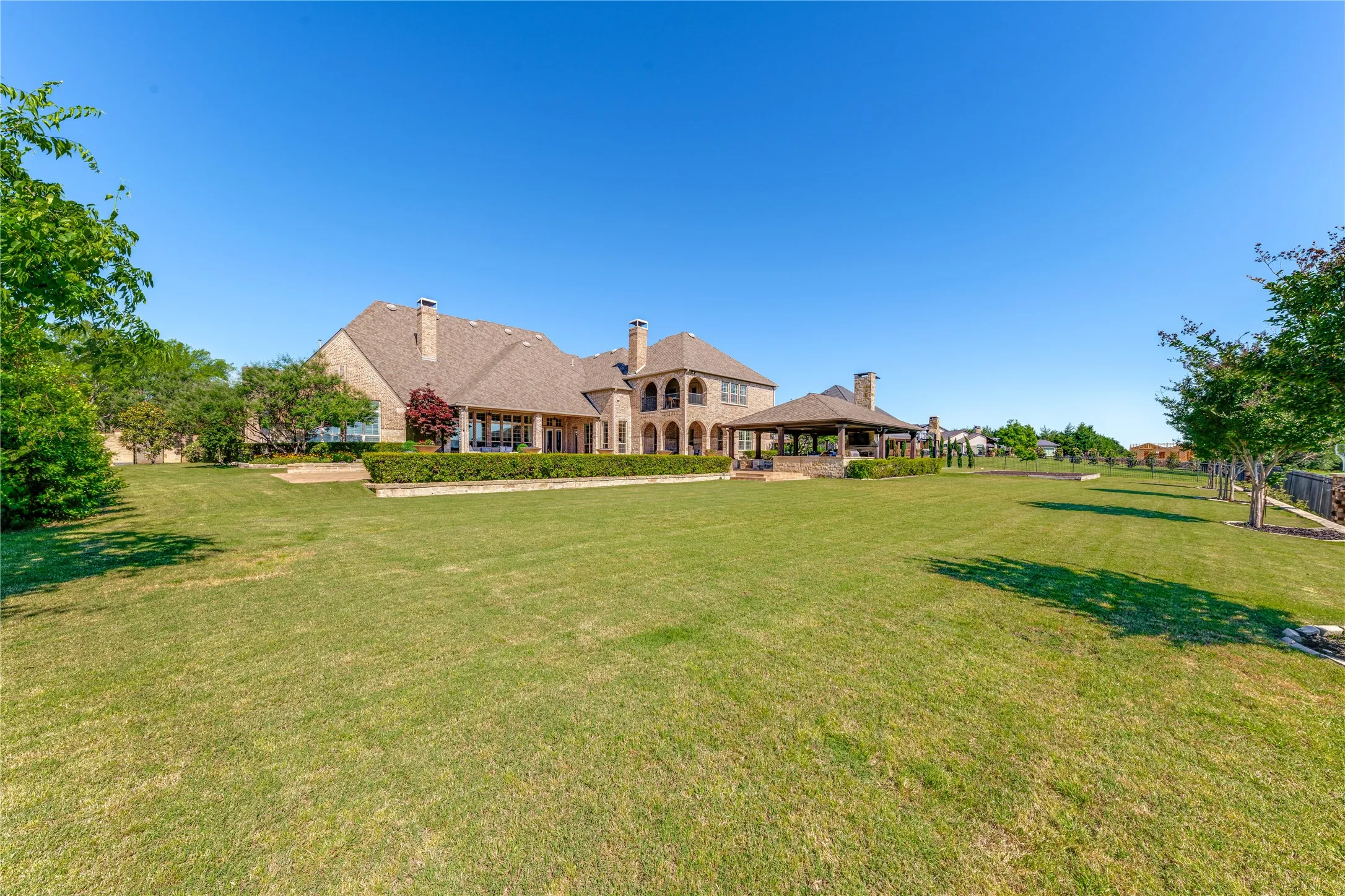 This exceptional 1 acre lot is ideal for kids & pets to play! Four covered areas along the back-golf course side-of the home: broad patio off the great room, upper balcony & lower patio + the outdoor pavilion. All with sweeping views of treelines, rolling hills, manicured fairways.