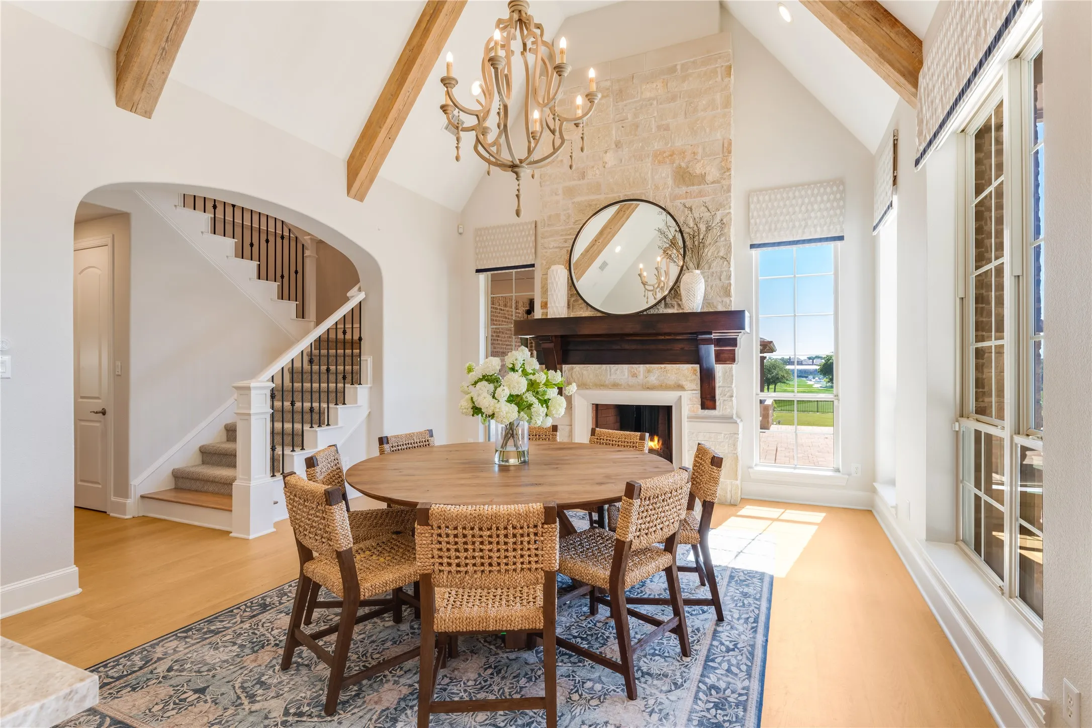 This casual dining room strikes the perfect balance between relaxed & refined. Anchored by the stone fireplace & vaulted beam ceiling, the windows fill the room with light & sweeping views of the golf course & swimming pool. Automated blinds for evening privacy too.