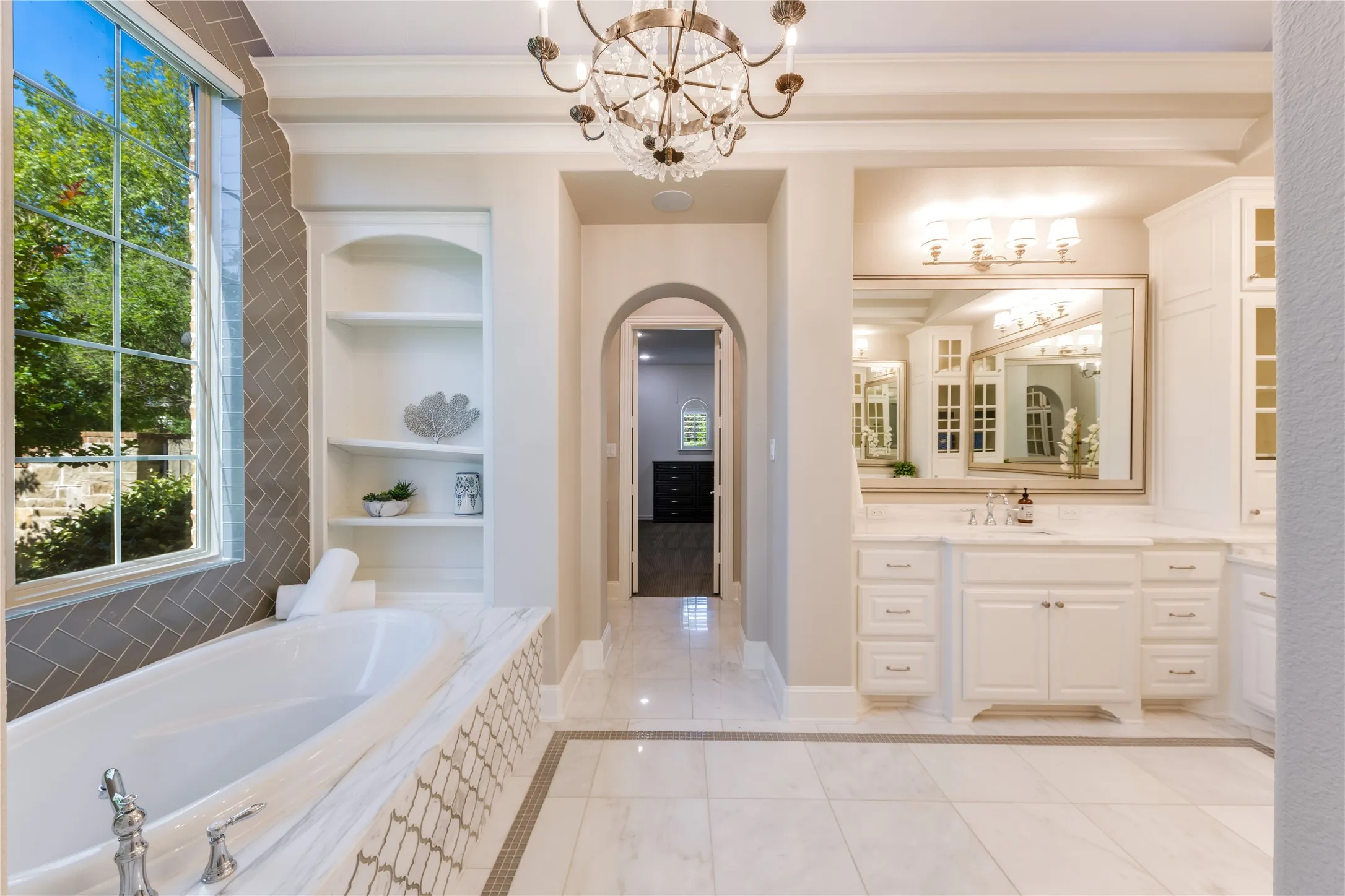 Timeless elegance in the primary bath boasting marble countertops, a large soaking tub & a deep walk-in shower with dual shower heads.