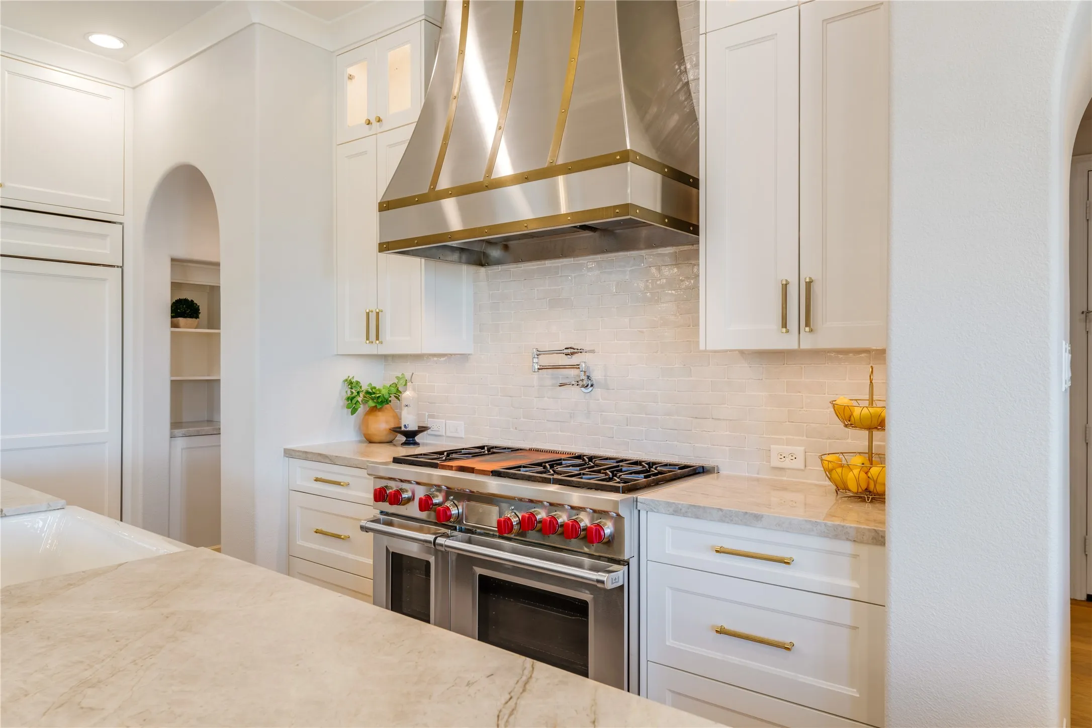 Unrivaled quality for the family chef, a professional-grade 48" dual fuel Wolf Range with griddle section & a Wolf convection steam oven, handy pot filler, stainless vent hood. Note the lighted upper cabinets too.