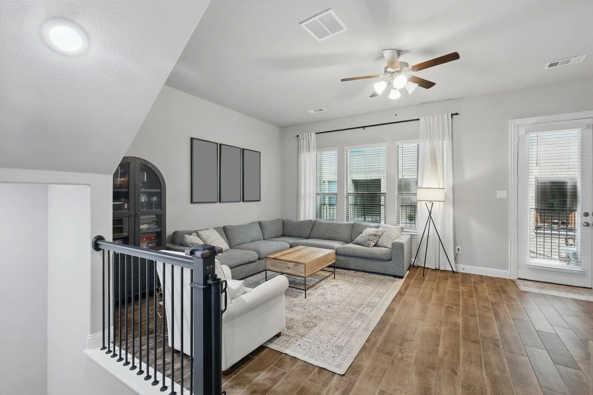 Living room with visible vents, baseboards, ceiling fan, and dark wood-style floors