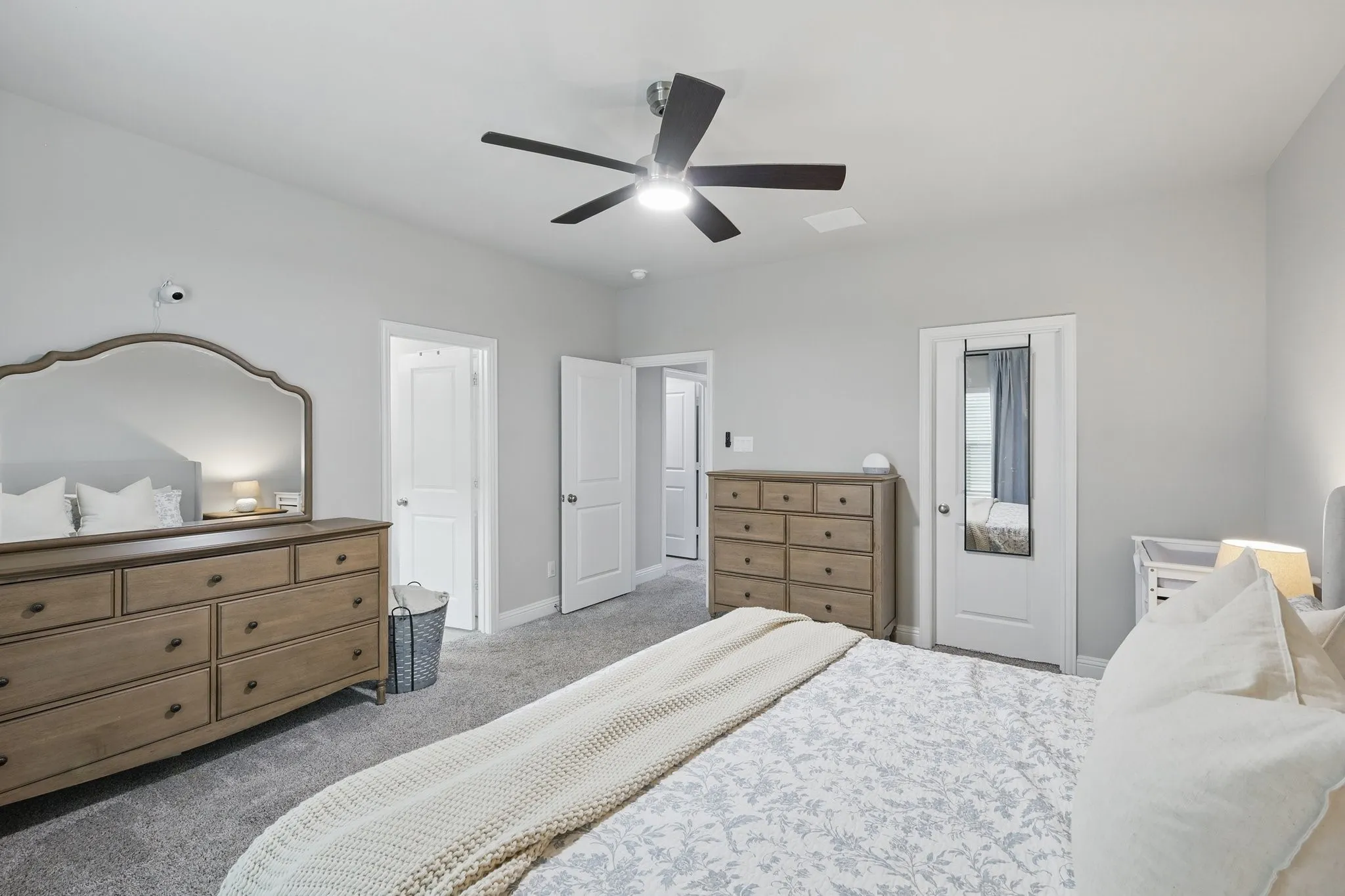 Carpeted bedroom featuring ceiling fan and baseboards