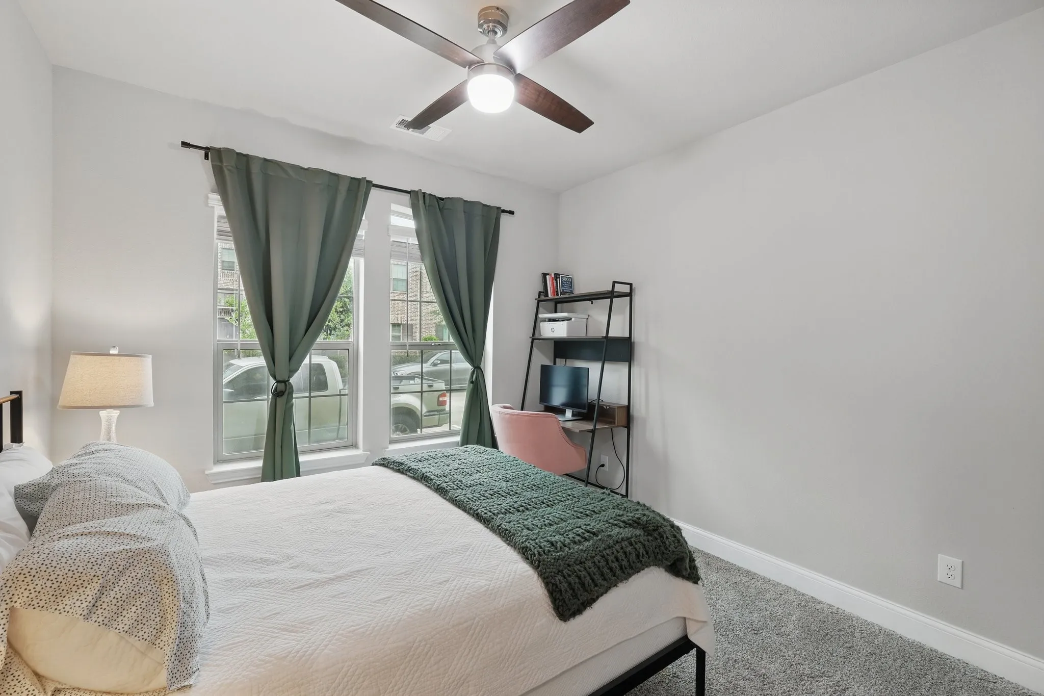 Carpeted bedroom featuring baseboards and a ceiling fan
