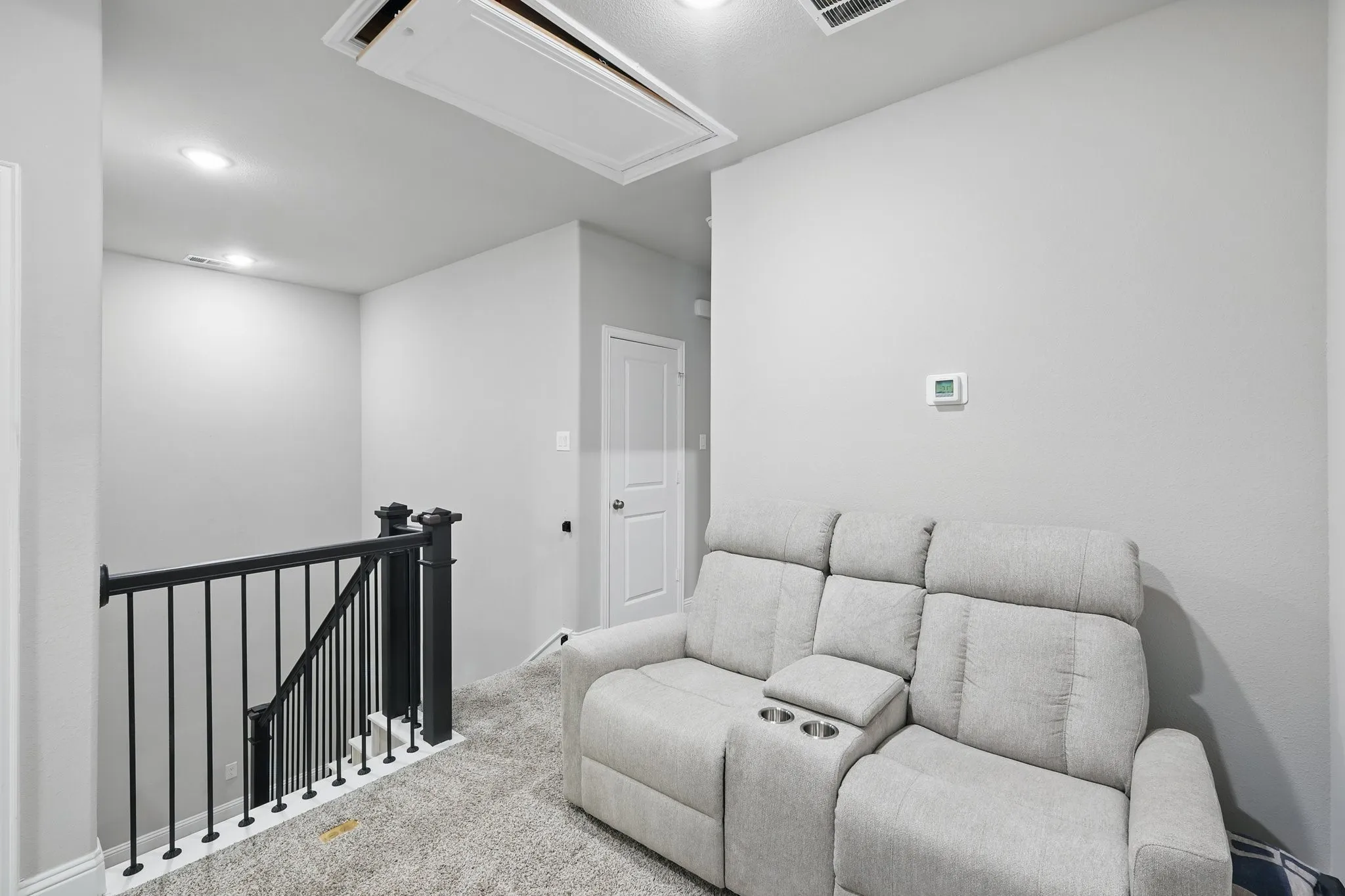 Carpeted living room featuring attic access and recessed lighting