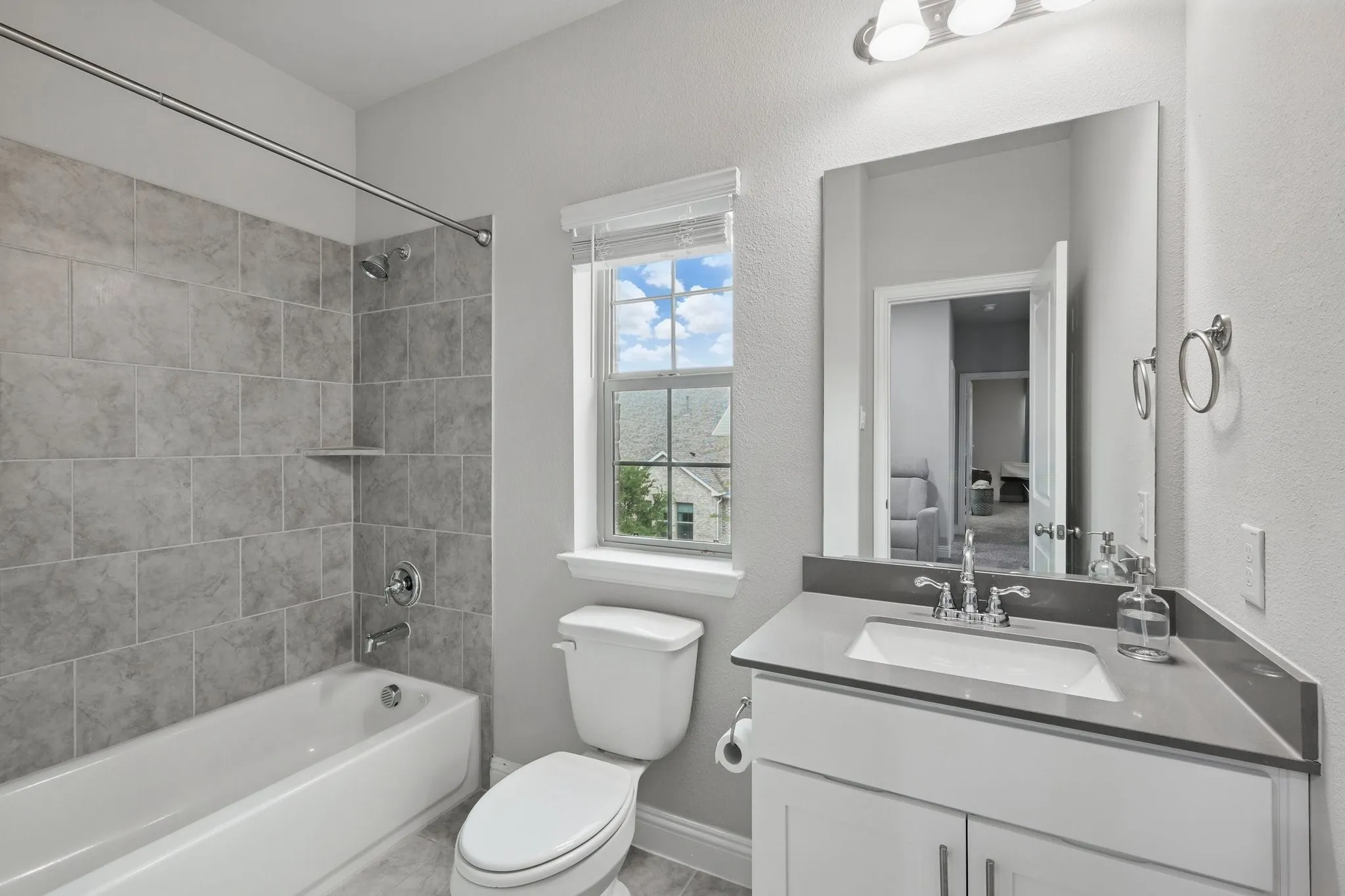 Bathroom featuring vanity, toilet, shower / washtub combination, and baseboards