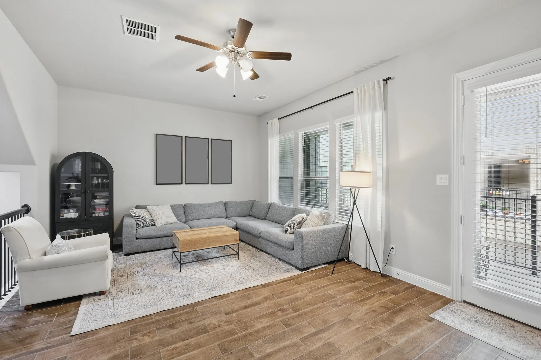 Living area featuring a ceiling fan, baseboards, visible vents, and wood finished floors