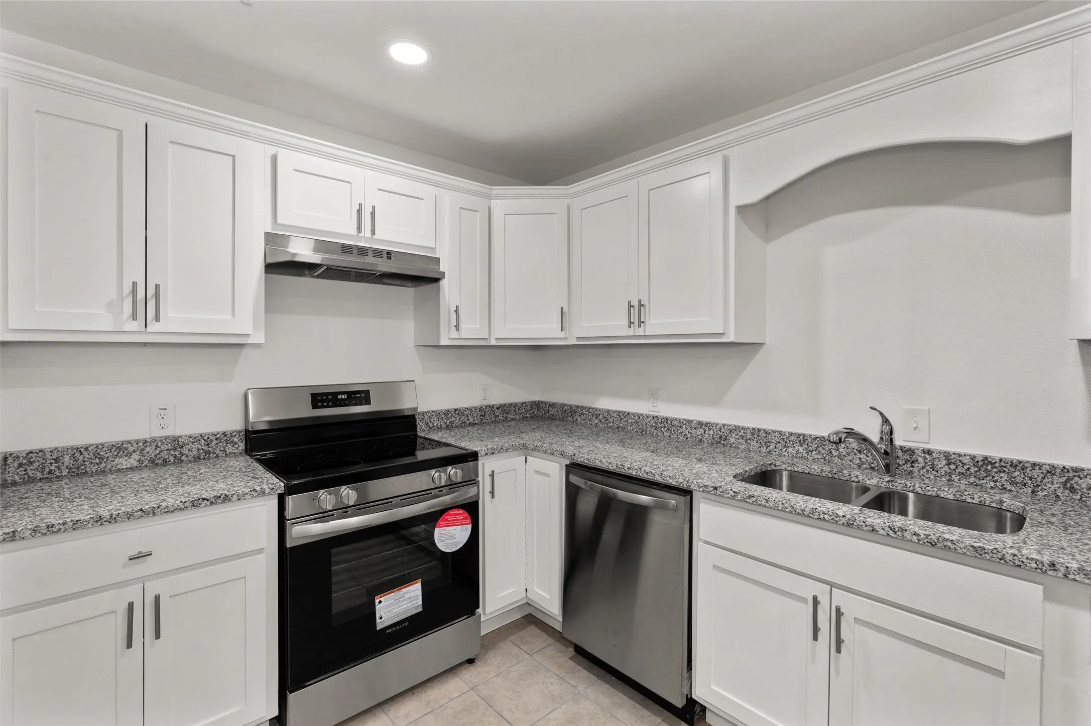 Kitchen featuring appliances with stainless steel finishes, a sink, white cabinetry, recessed lighting, and under cabinet range hood