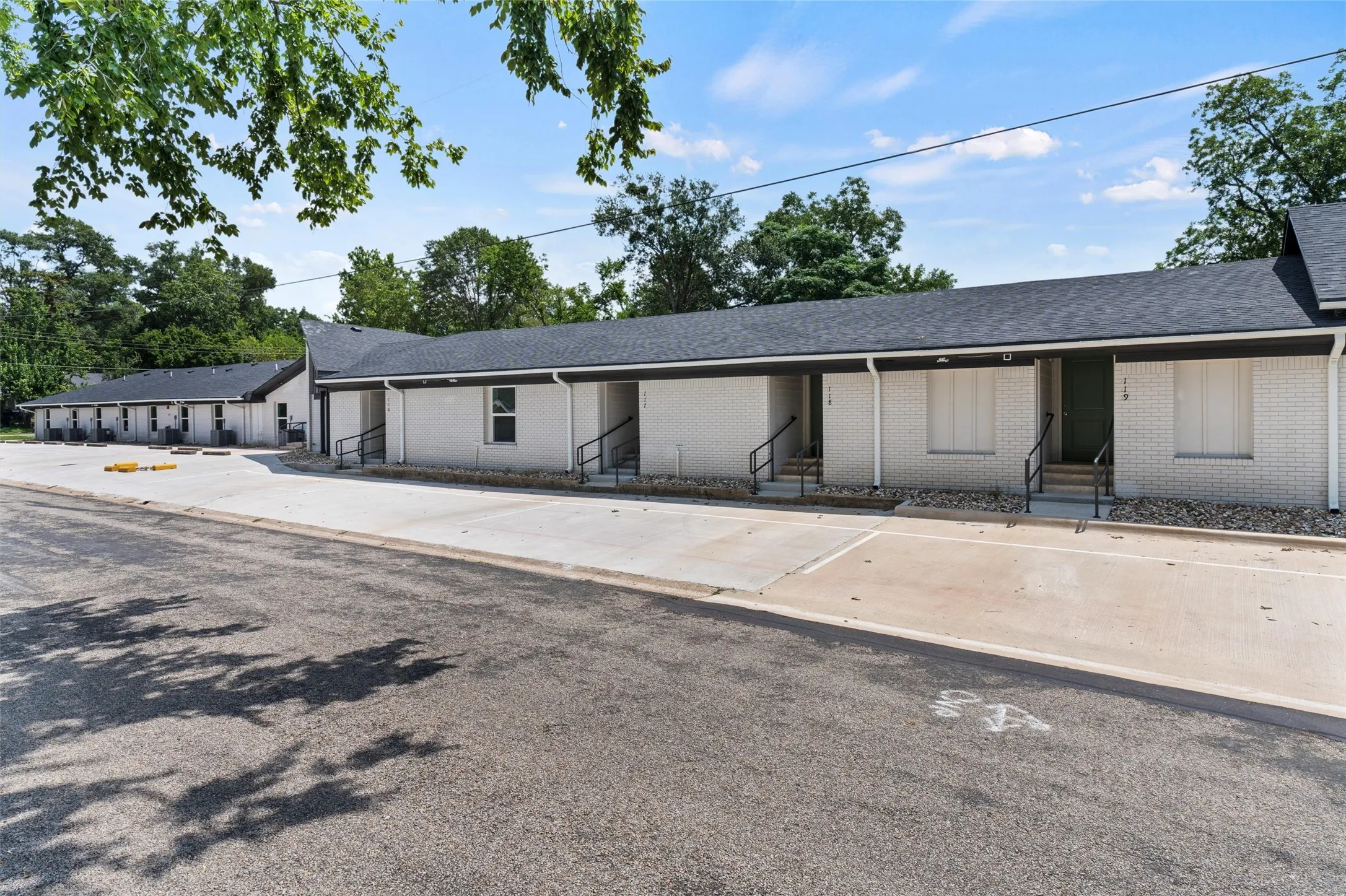 Ranch-style house featuring brick siding, uncovered parking, entry steps, and roof with shingles