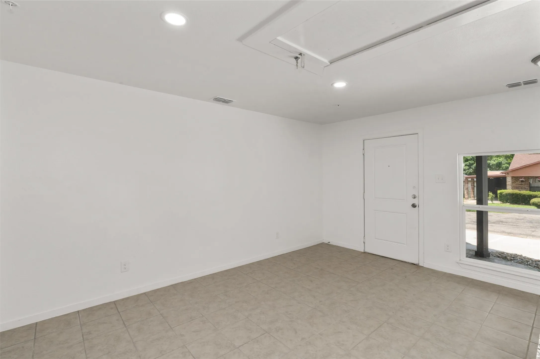 Empty room featuring recessed lighting, visible vents, and attic access