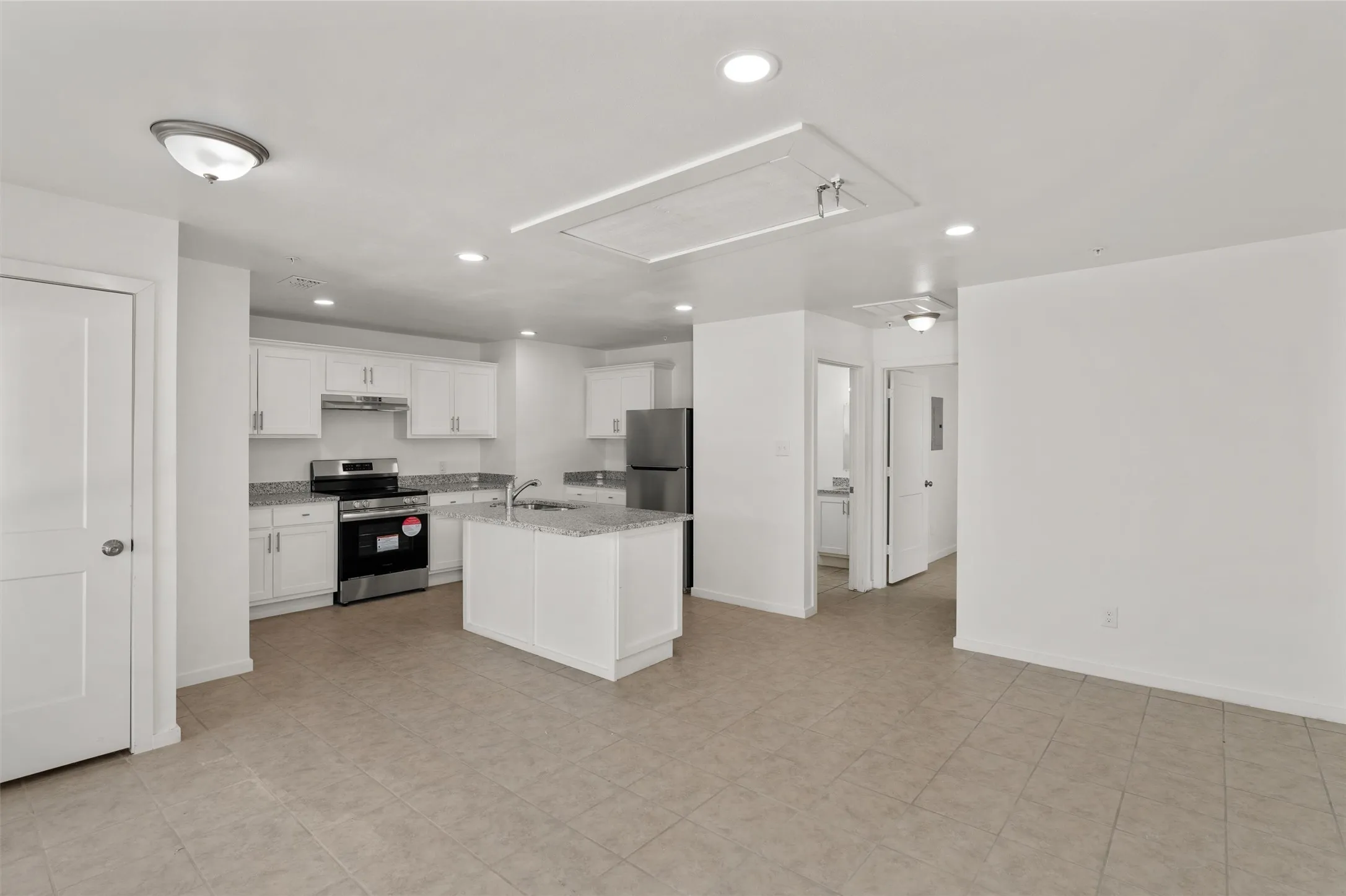 Kitchen featuring a sink, appliances with stainless steel finishes, recessed lighting, and white cabinetry