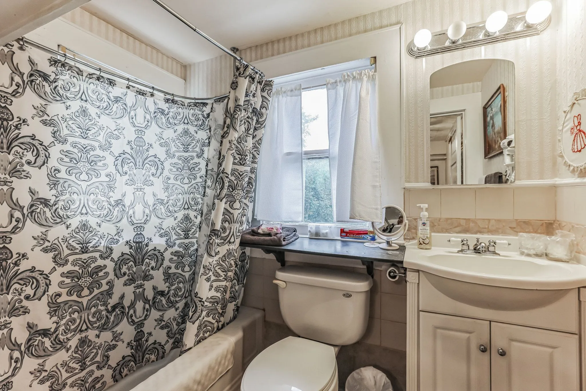Bathroom featuring shower / bath combo, backsplash, toilet, and vanity
