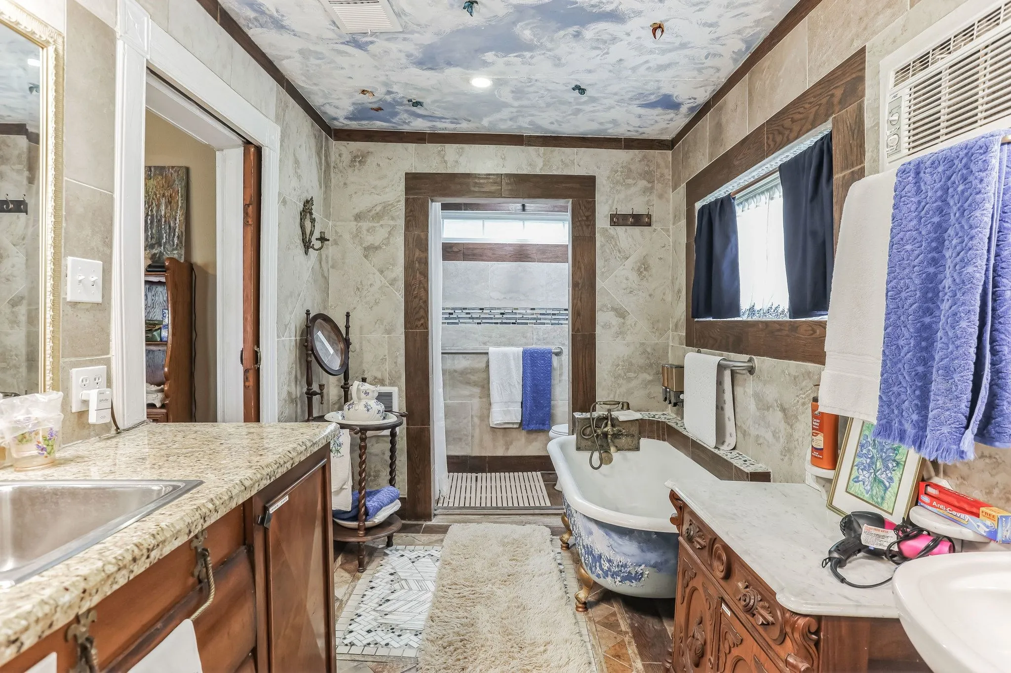 Bathroom featuring crown molding, tile walls, and a freestanding bath