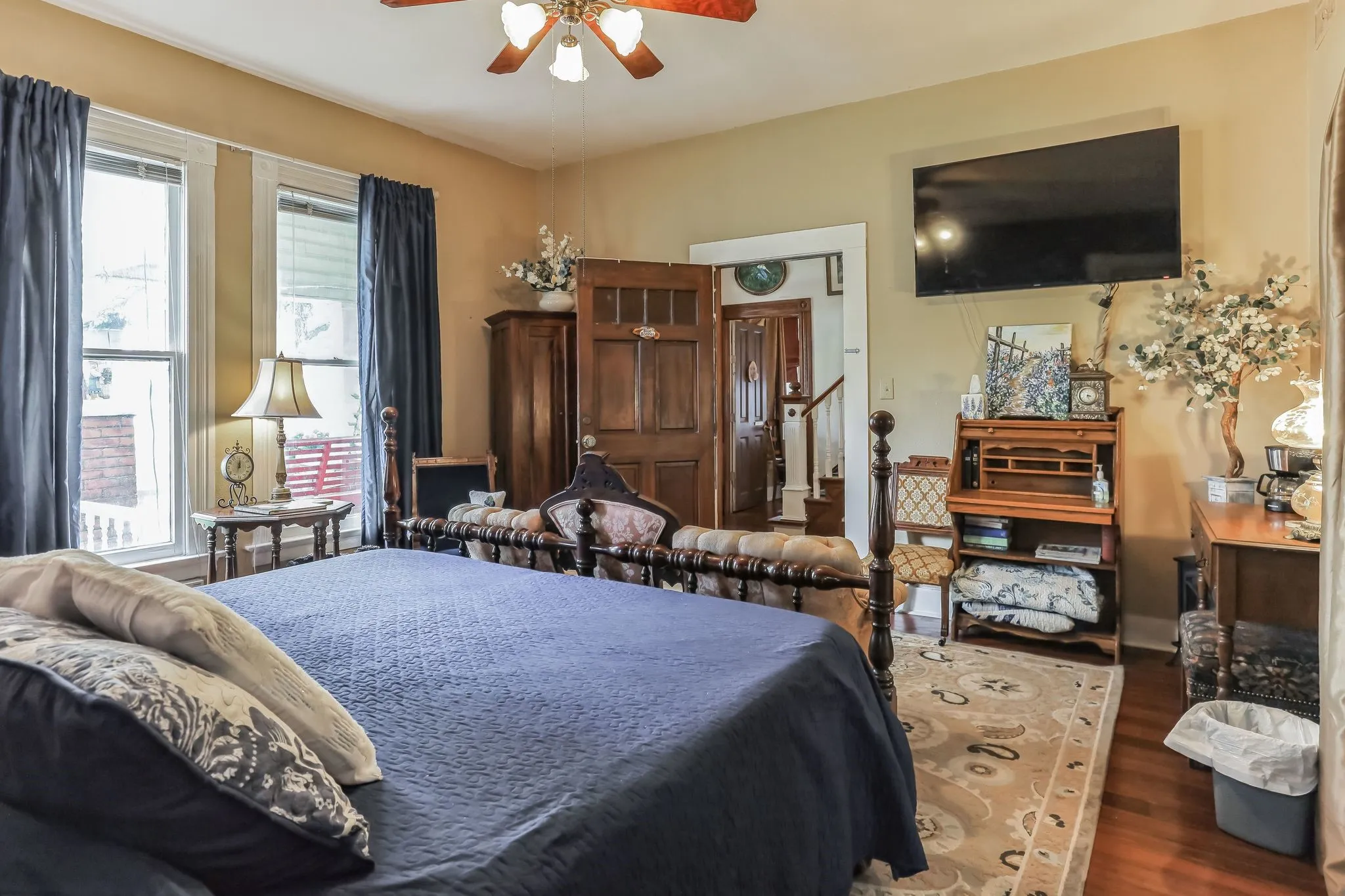 Bedroom with multiple windows, wood finished floors, and a ceiling fan